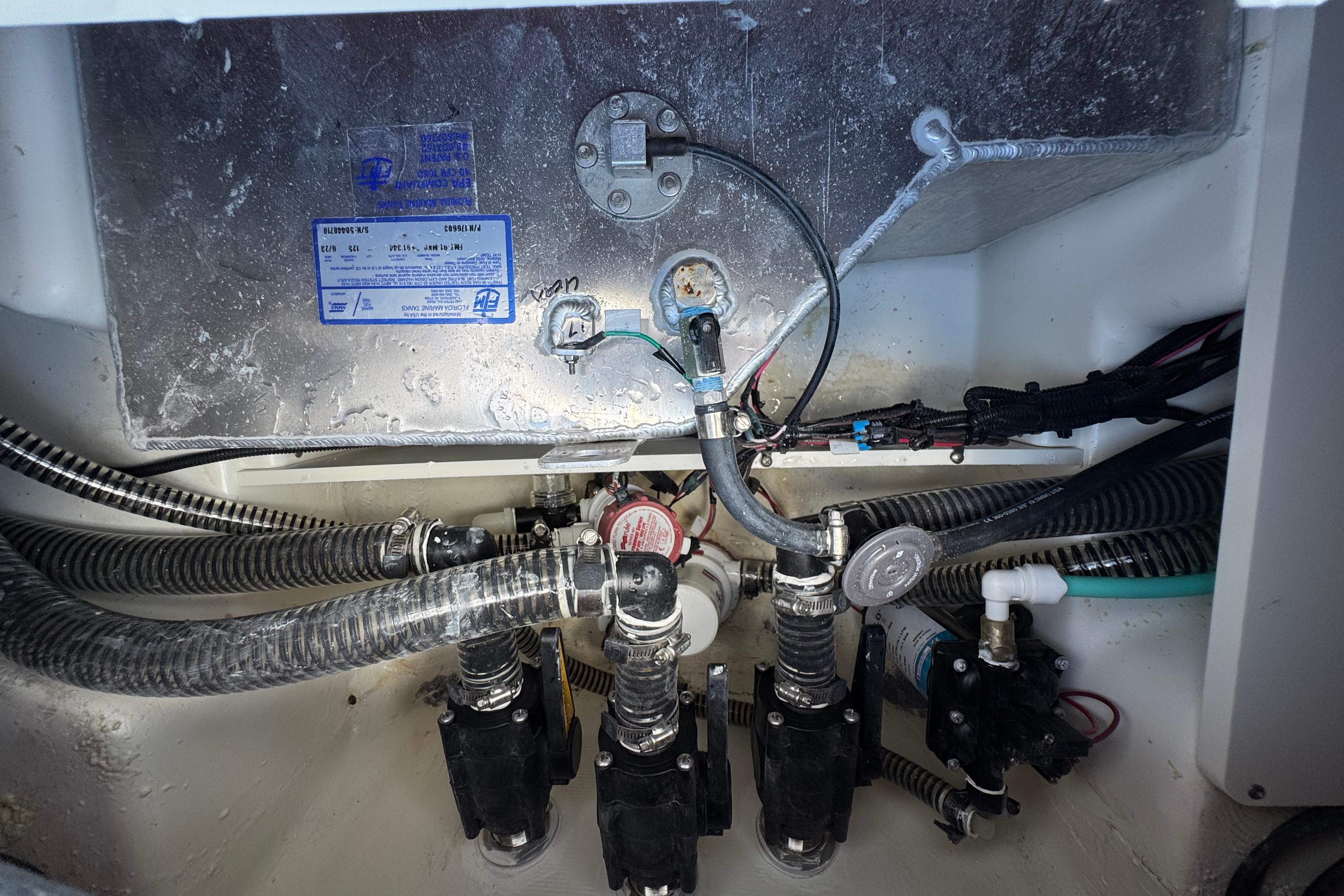 Engine compartment of a 2026 Mako 214 Center Console boat, showing wiring and plumbing.