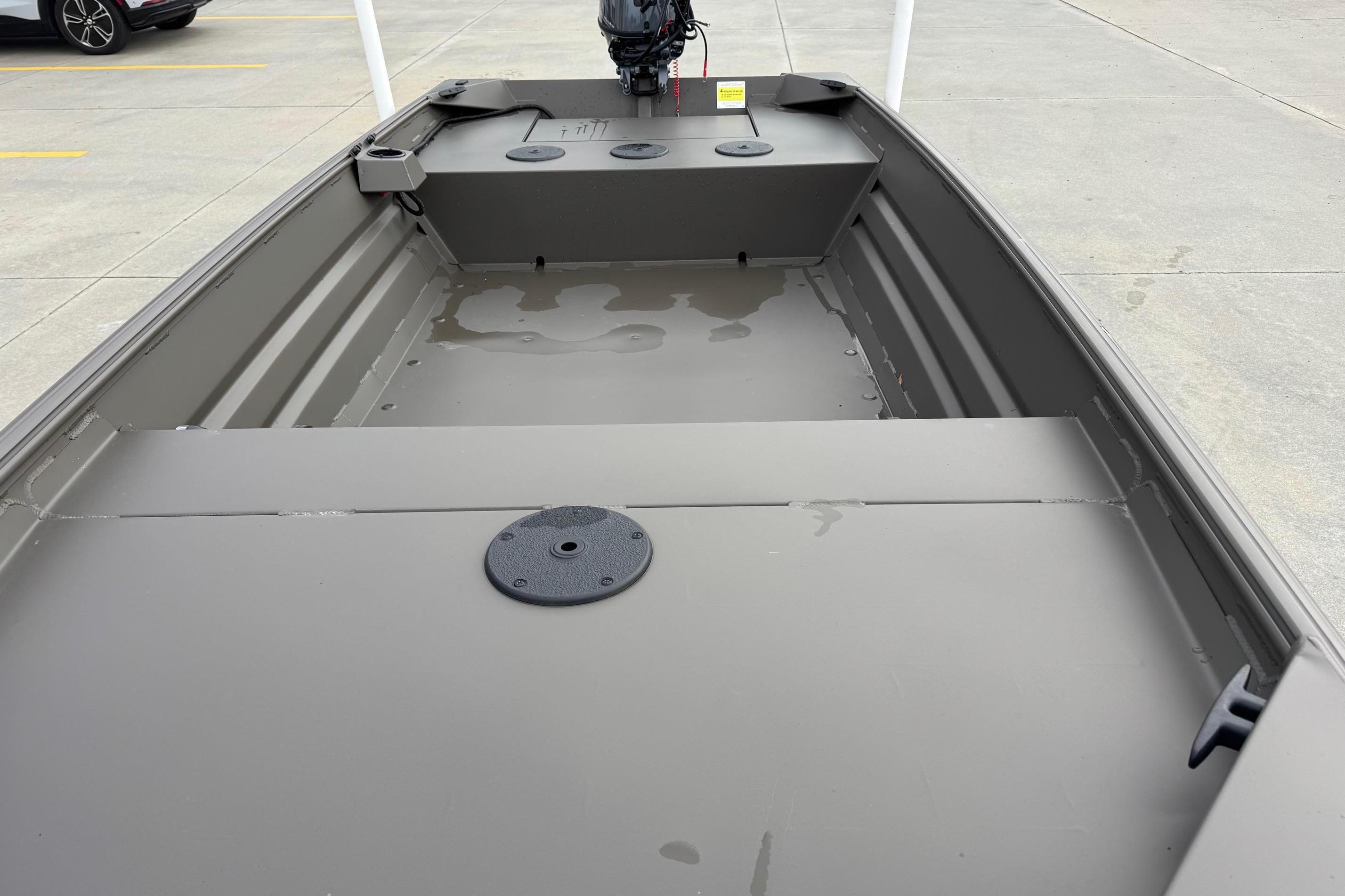 2026 Alweld 1548VV Marsh boat interior with motor, parked on concrete.