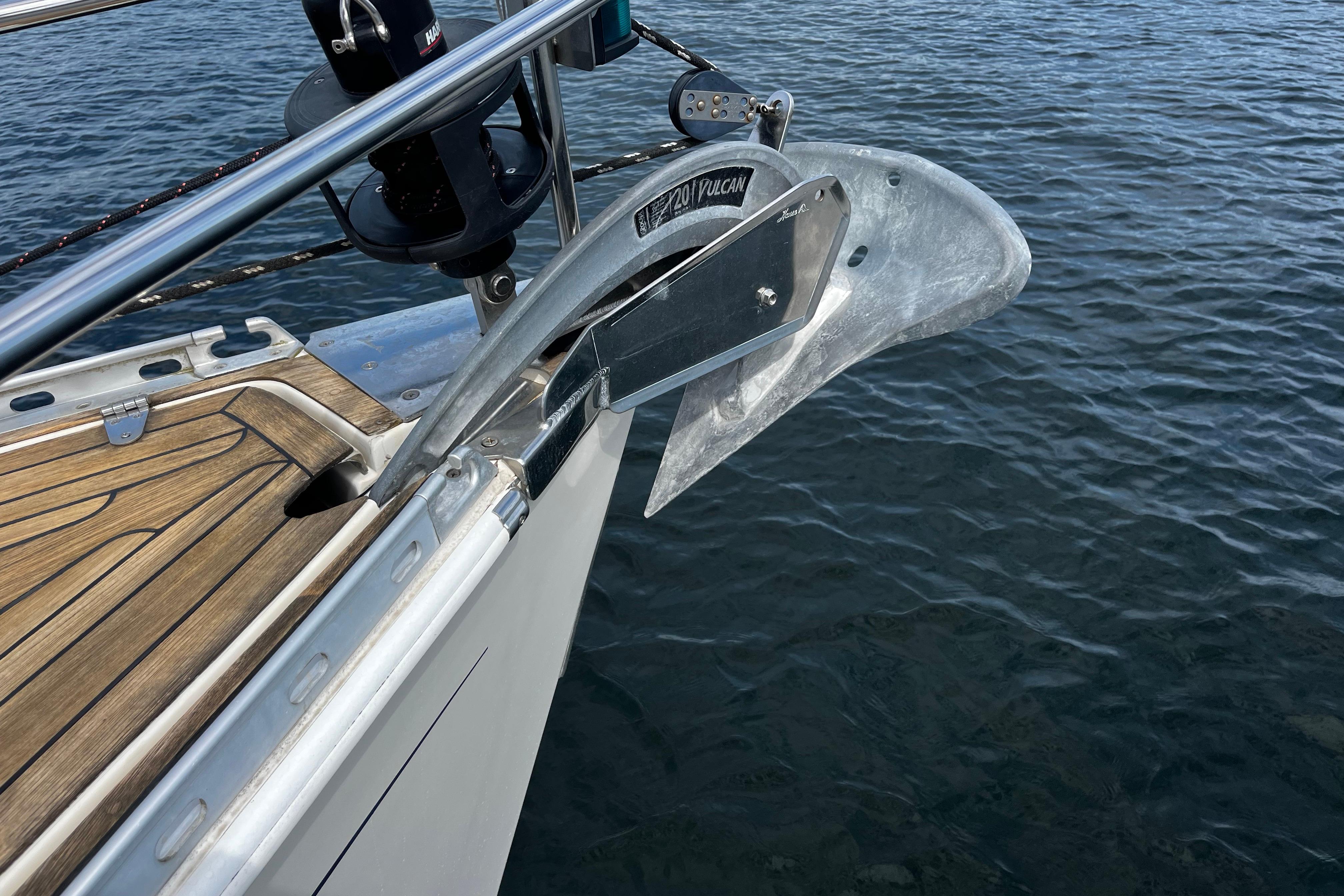 Bow of 2004 Hanse 411 yacht with anchor over calm water.