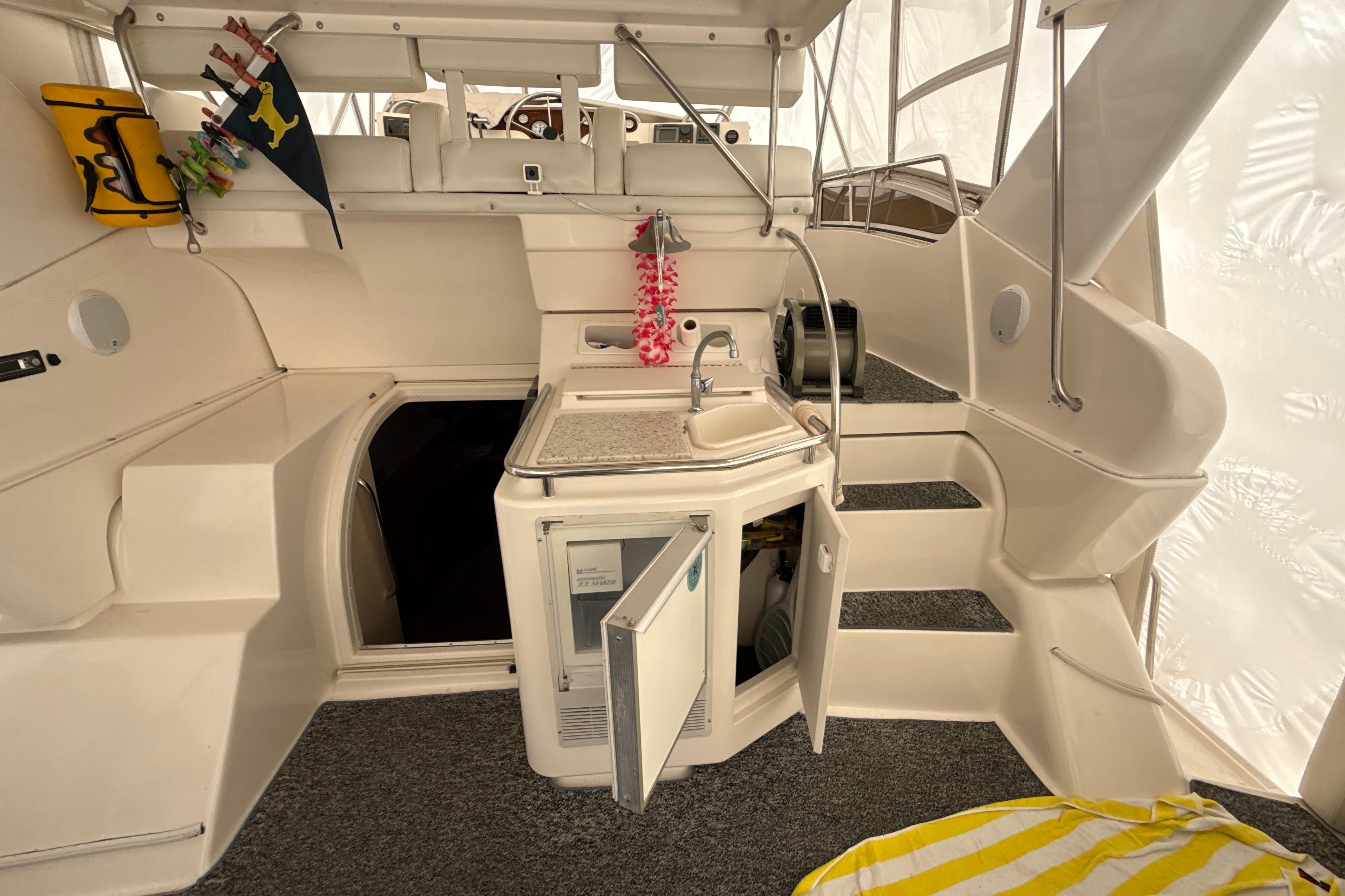 1999 Silverton 422 Motor Yacht interior with kitchenette, open cabinet, and stairs.