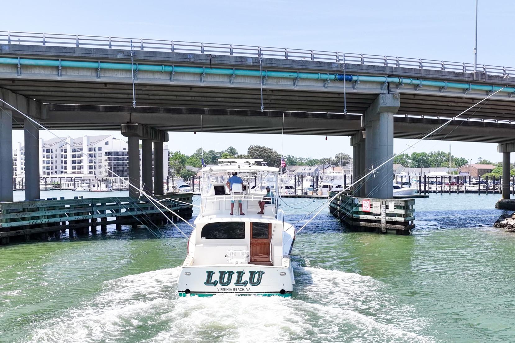 Blackwell Custom Carolina Sportfish 1998 boat navigating under a bridge in a marina setting.