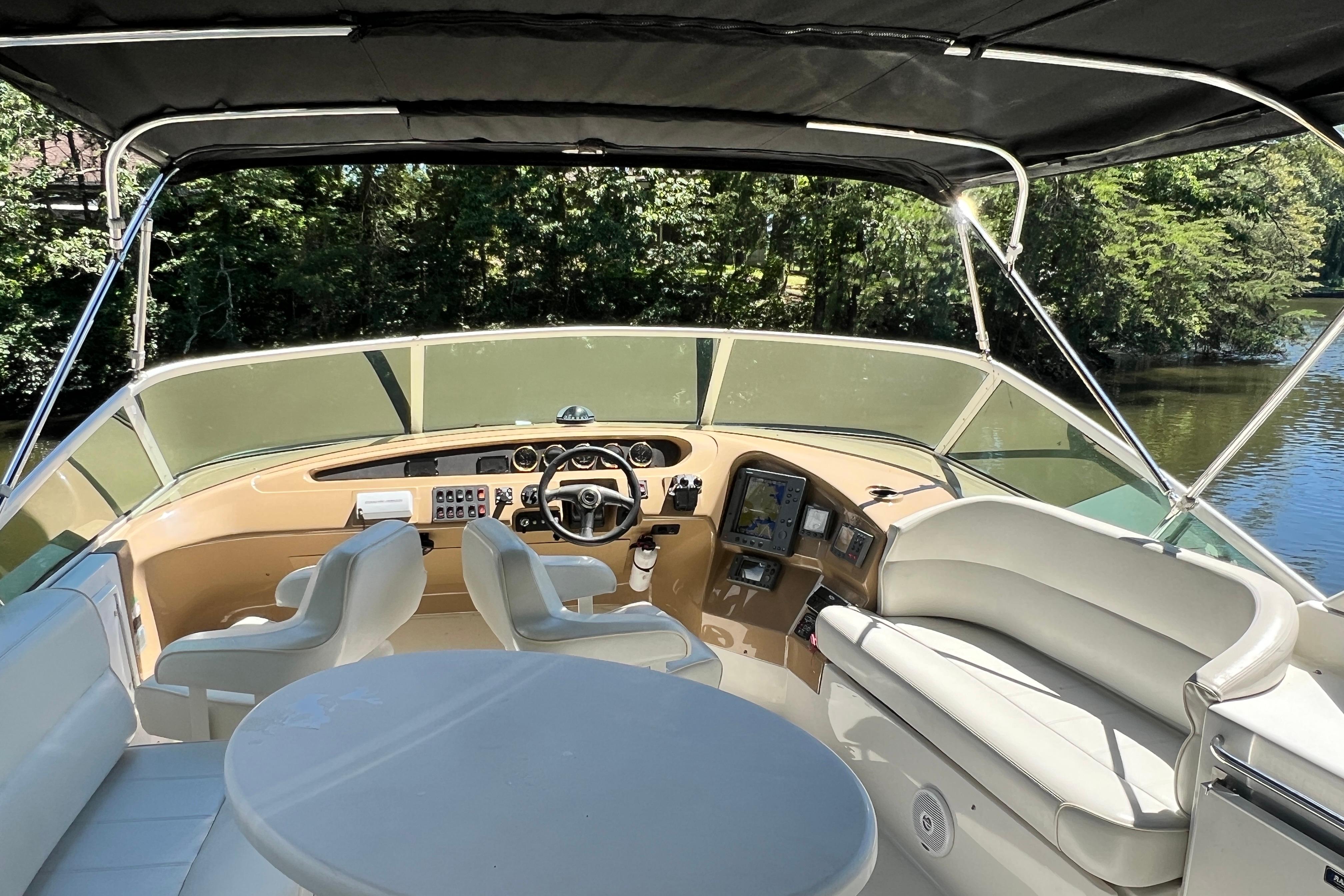 2003 Carver 450 Voyager Pilothouse helm with seating, steering wheel, and navigation equipment.