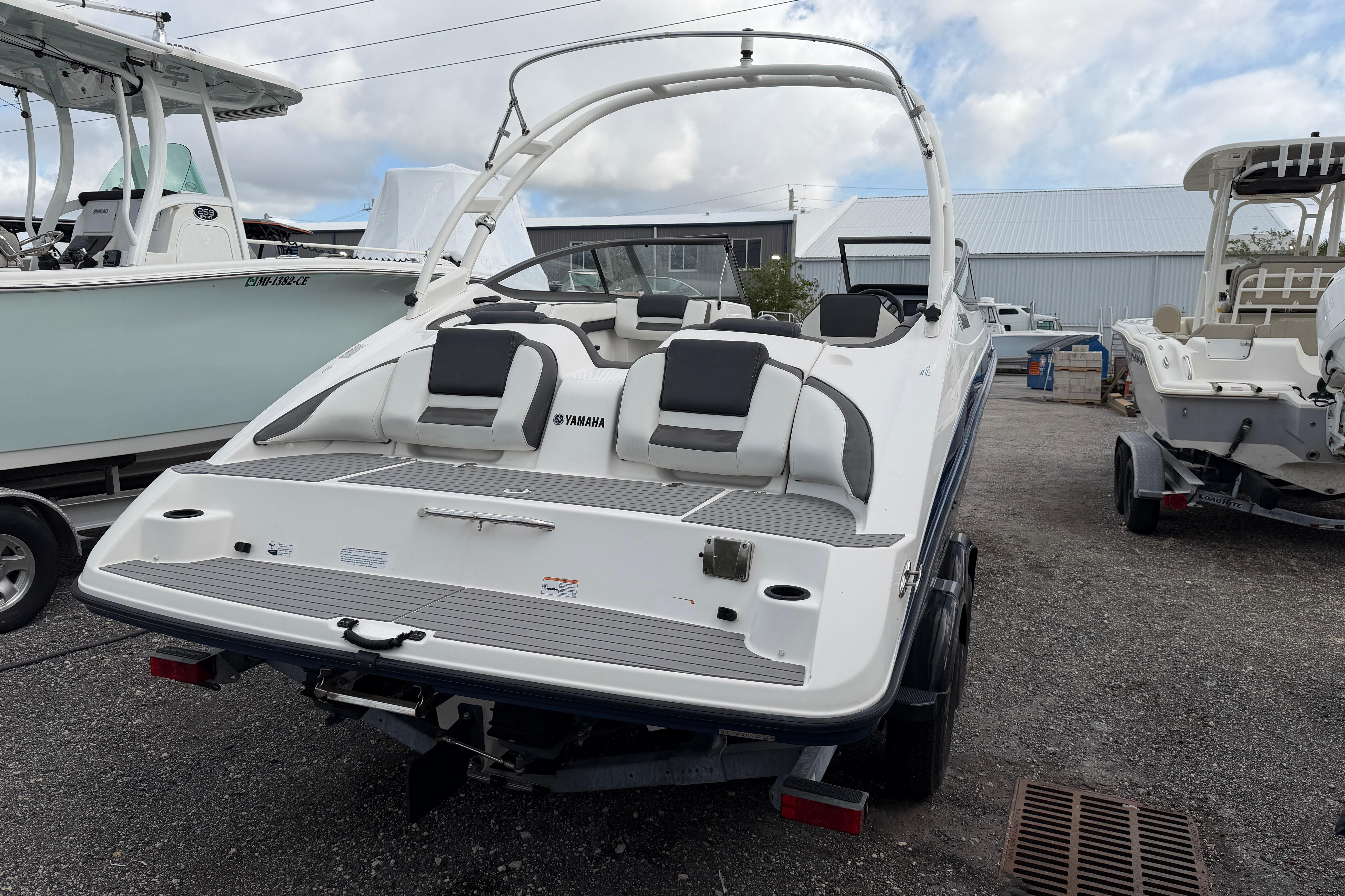 2022 Yamaha Boats AR210 on trailer, rear view in a boatyard setting.