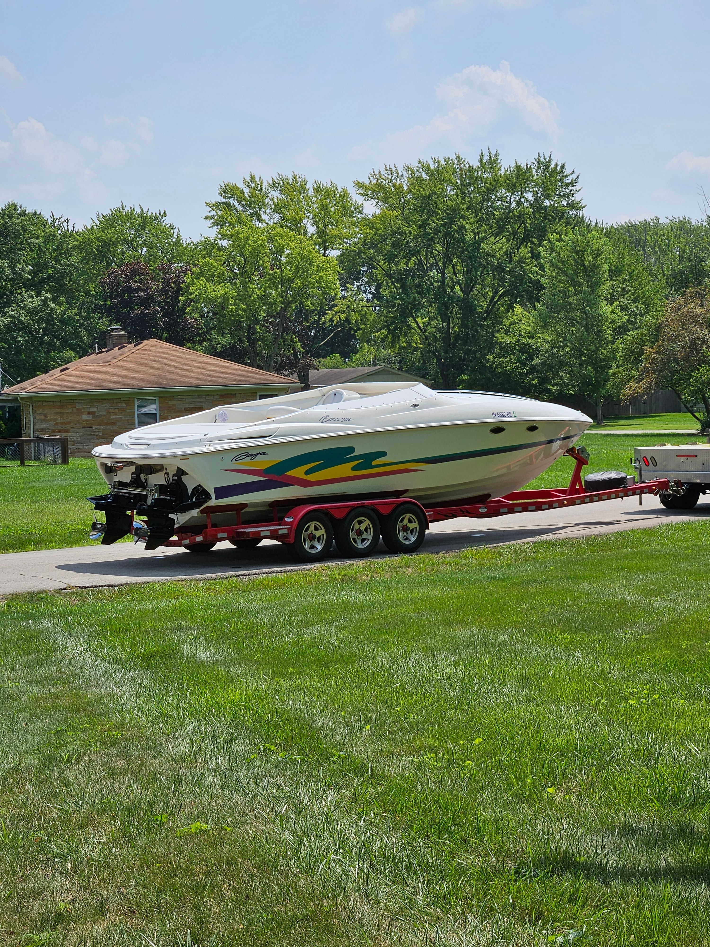 A 1996 Baja 302 Boss on a trailer, parked on a green lawn.