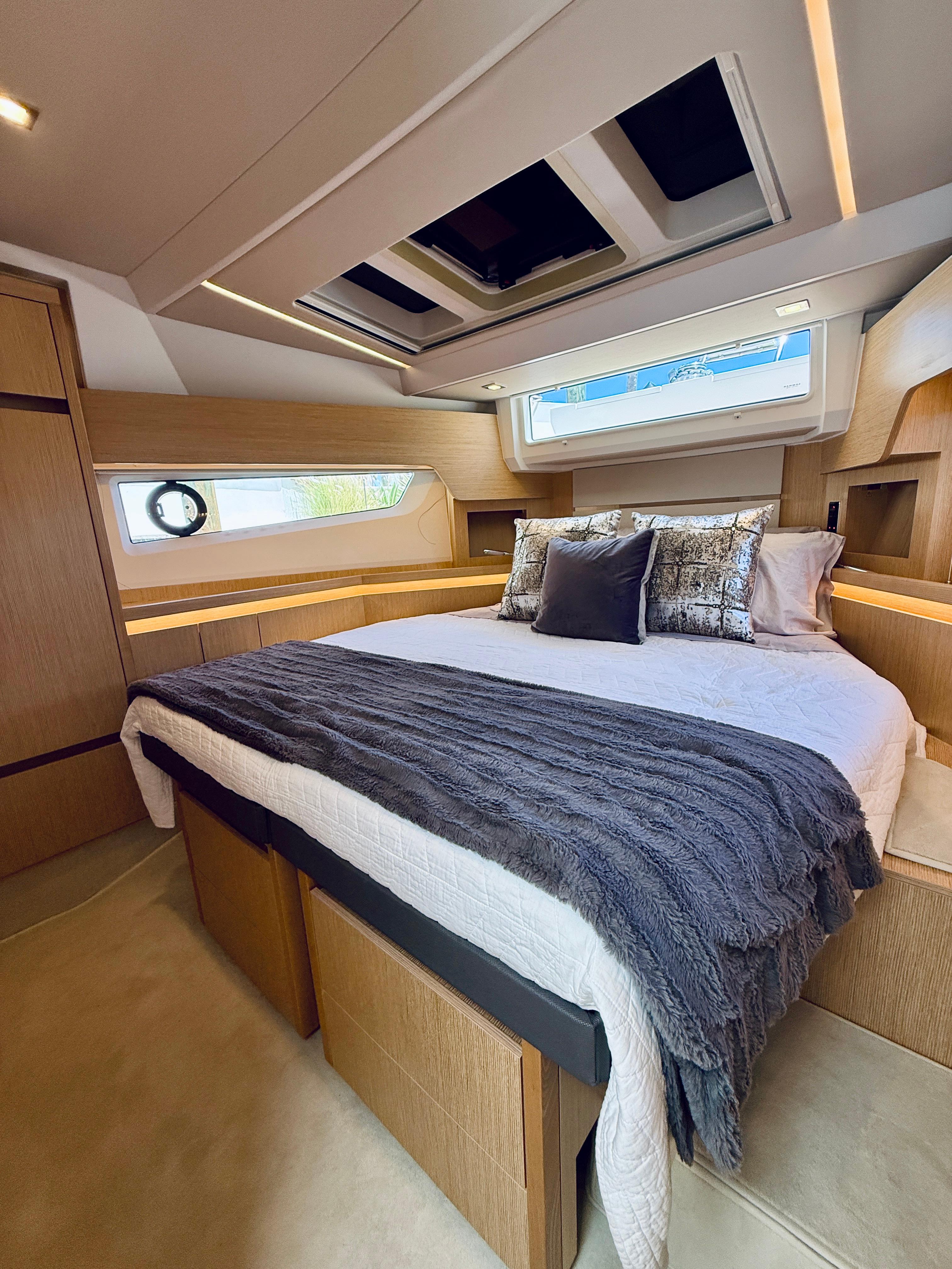 Luxurious 2019 Sealine F430 yacht bedroom with modern design and cozy bedding.