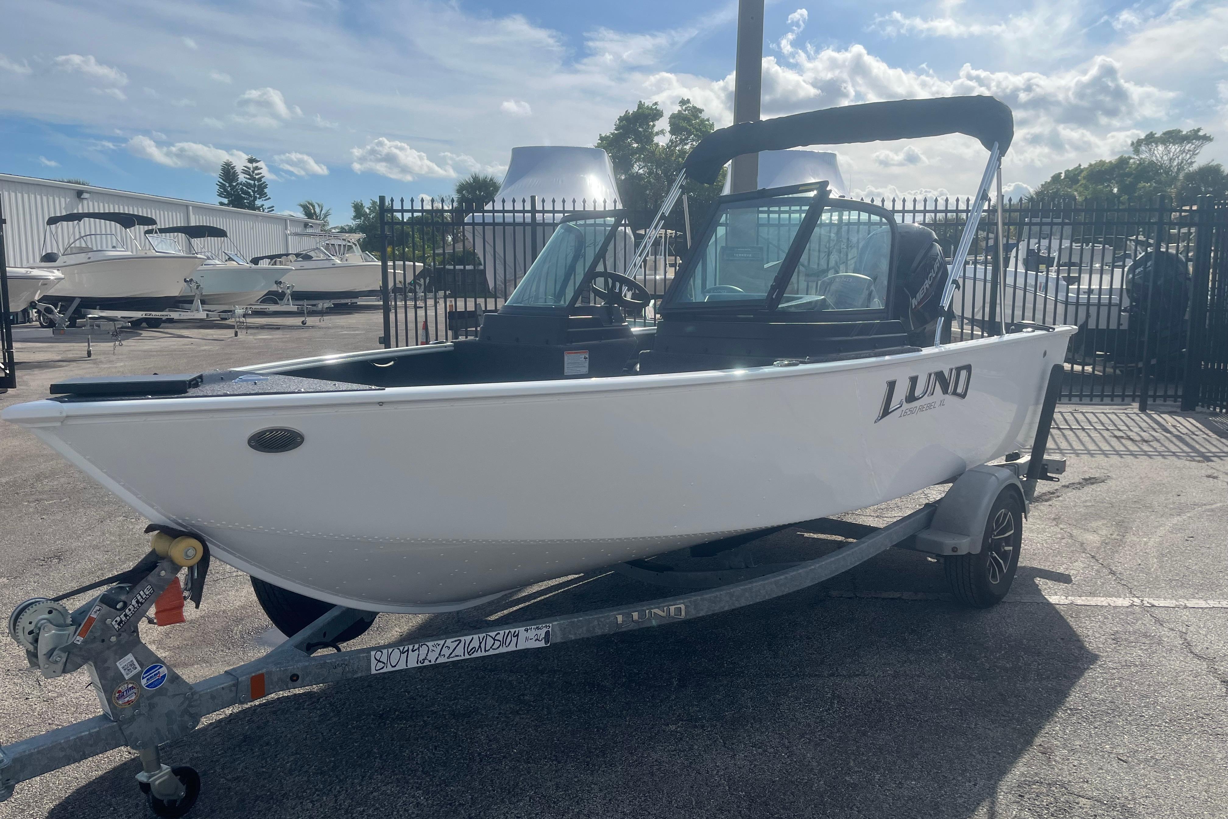 2026 Lund 1650 Rebel XL Sport boat on trailer, parked outdoors.