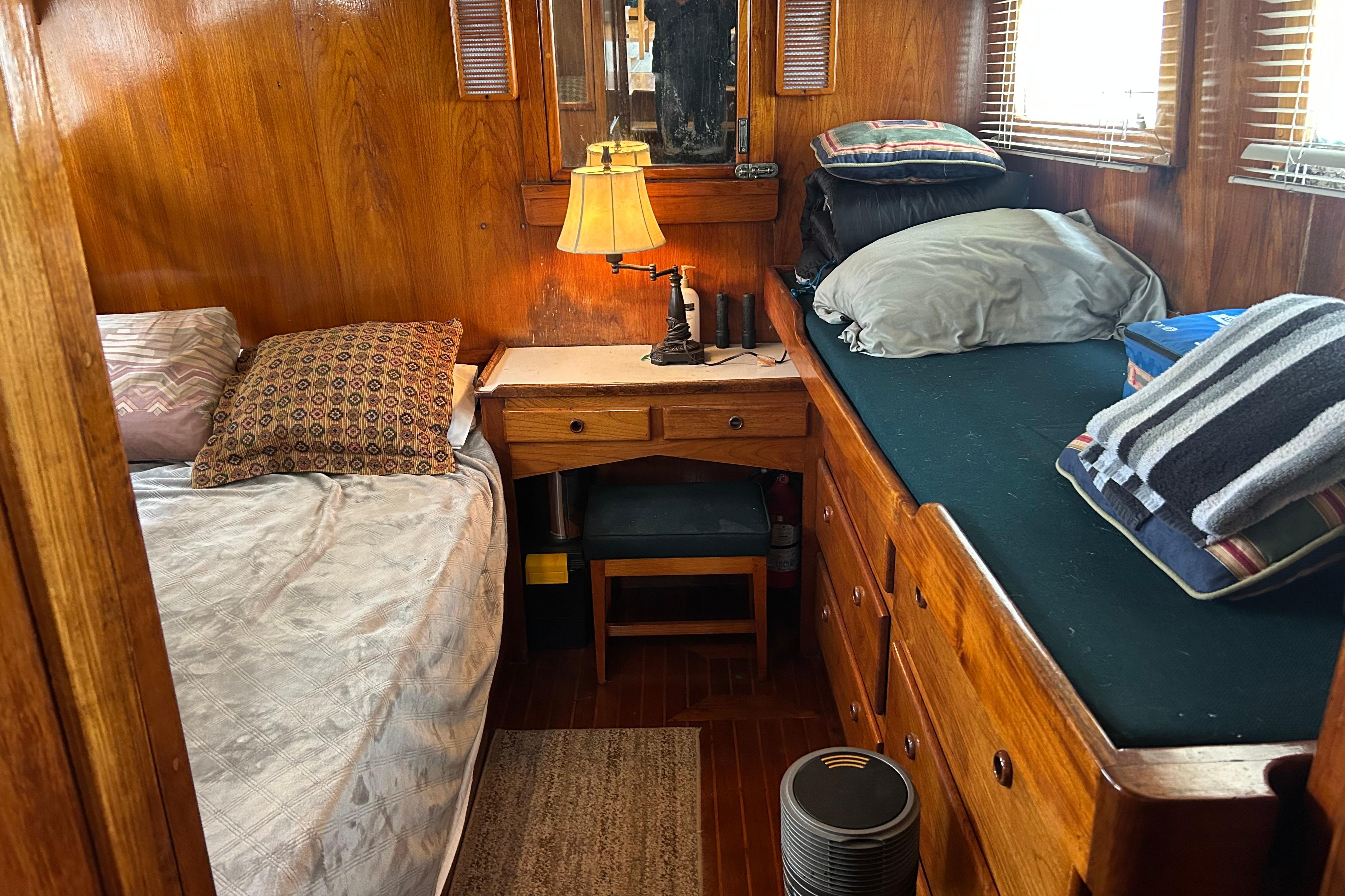 1976 Bristol Trawler cabin interior with wooden decor, twin beds, and a small desk.