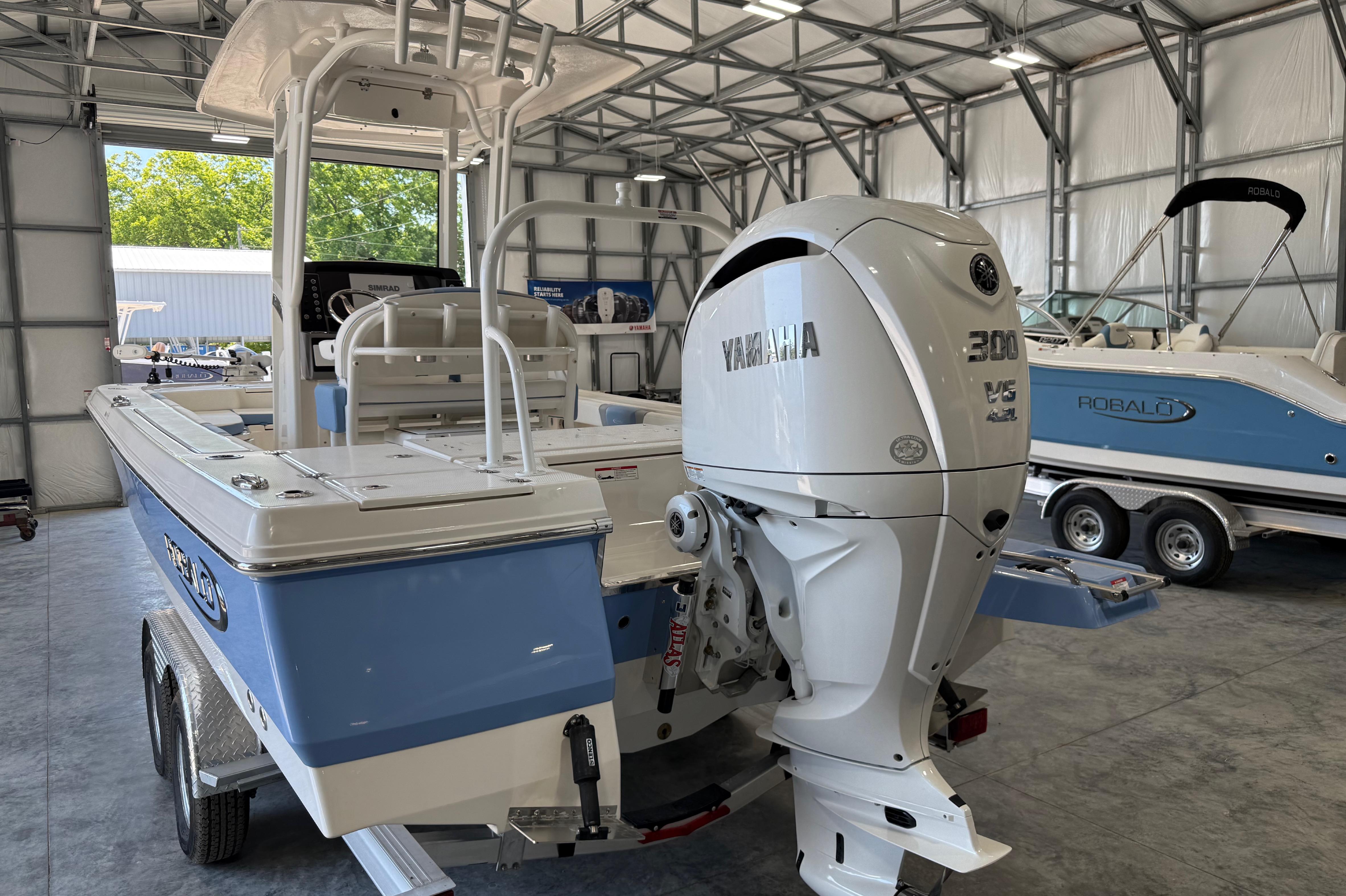 2026 Robalo 246 Cayman boat with Yamaha 300 engine in a storage facility.