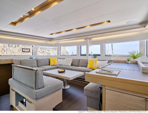 Luxurious interior of 2025 Lagoon 51 ICONIC yacht with modern seating and panoramic windows.