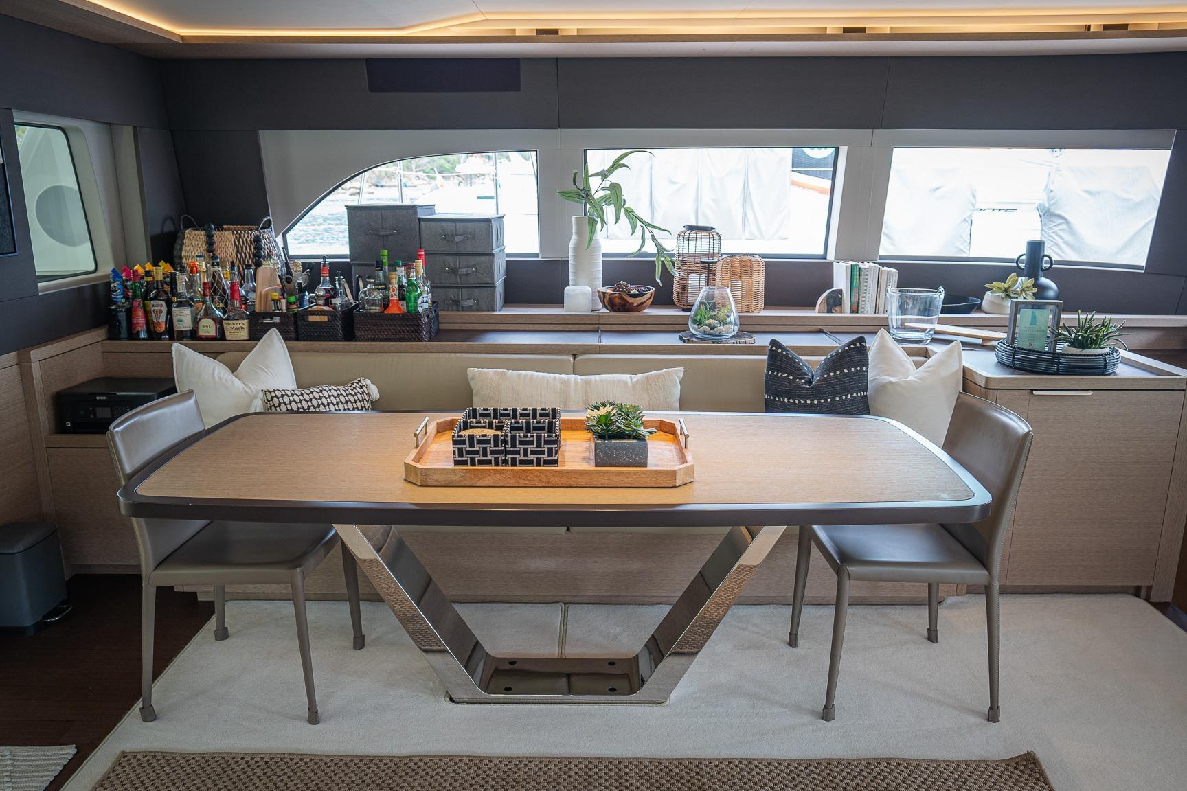 Luxurious interior of 2022 Lagoon SIXTY 7 yacht with elegant dining area and modern decor.