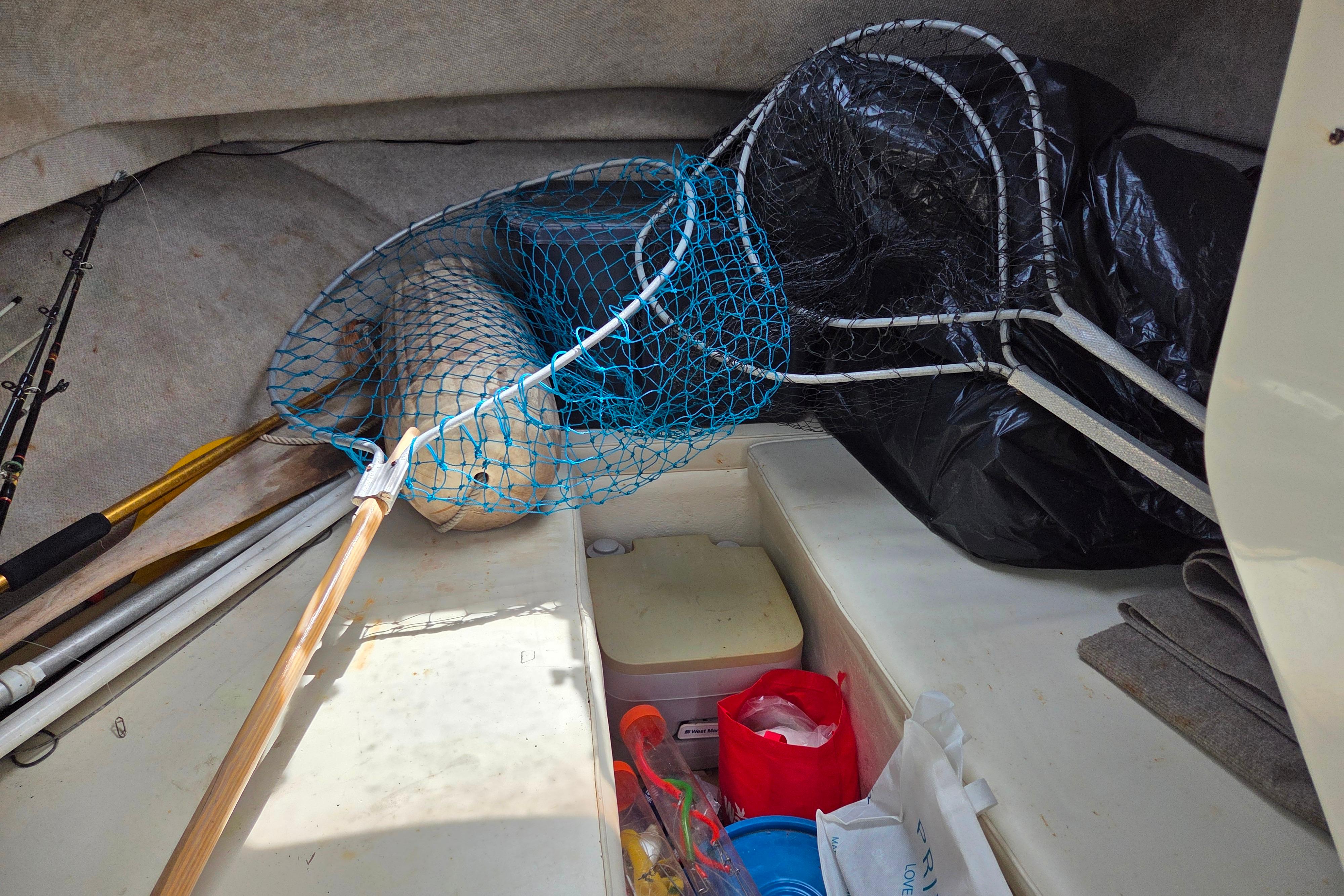 Interior of a 2002 Parker 2520 Deep Vee Sport Cabin with fishing gear and nets.