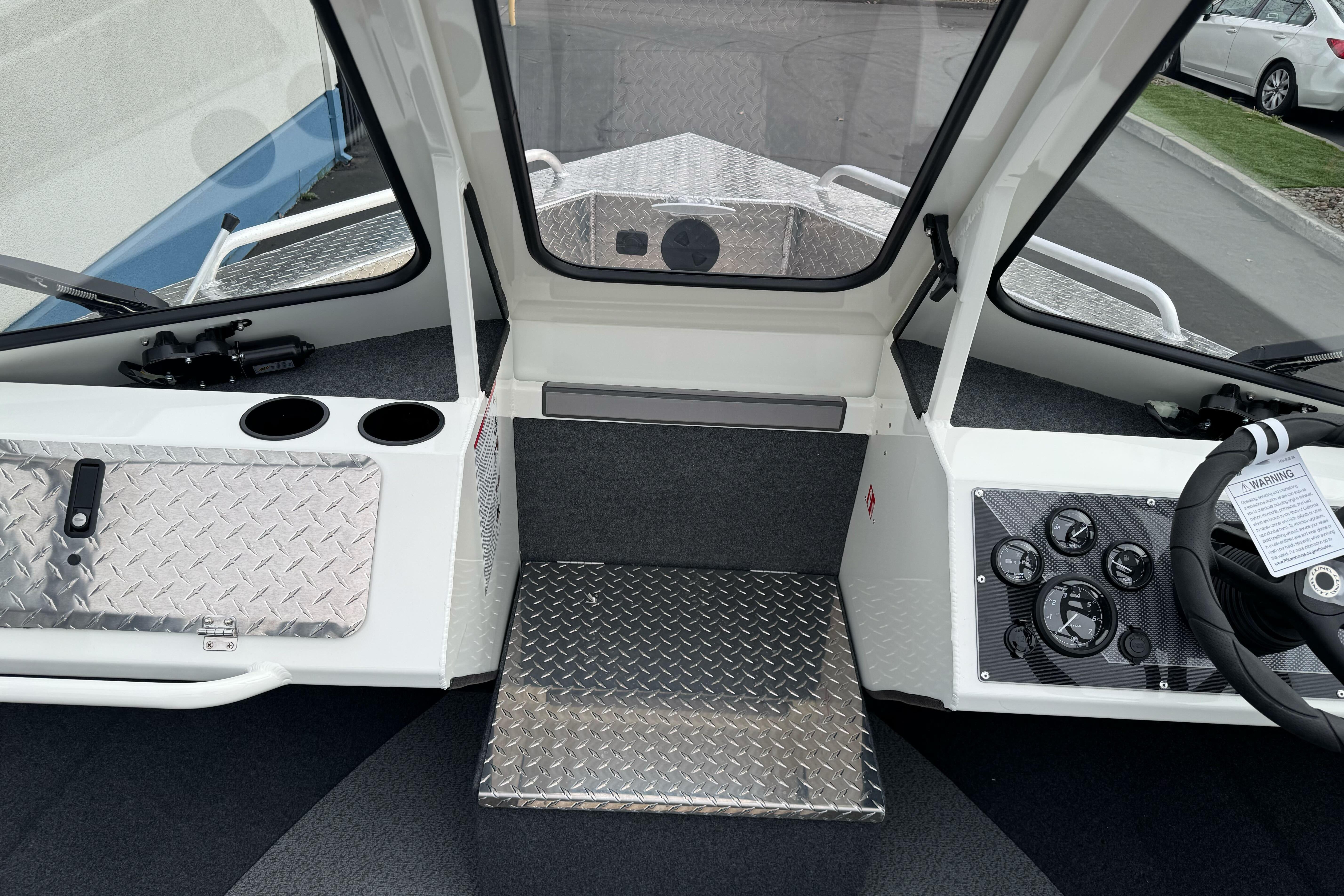 2026 Lund 185 Heavy Gauge boat interior with steering wheel, dashboard, and diamond plate flooring.