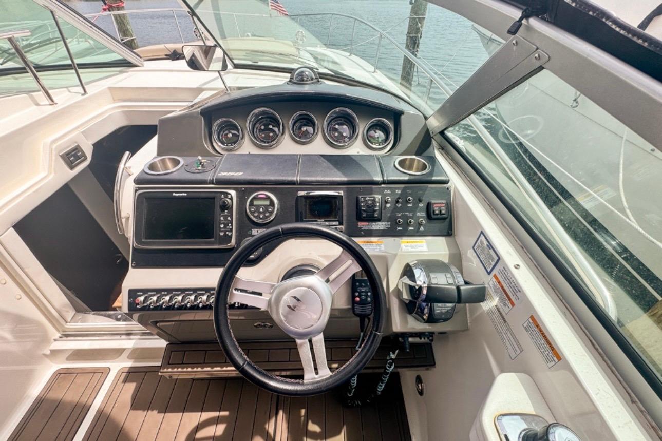 Cockpit of 2015 Sea Ray Sundancer 350 with steering wheel and navigation controls.