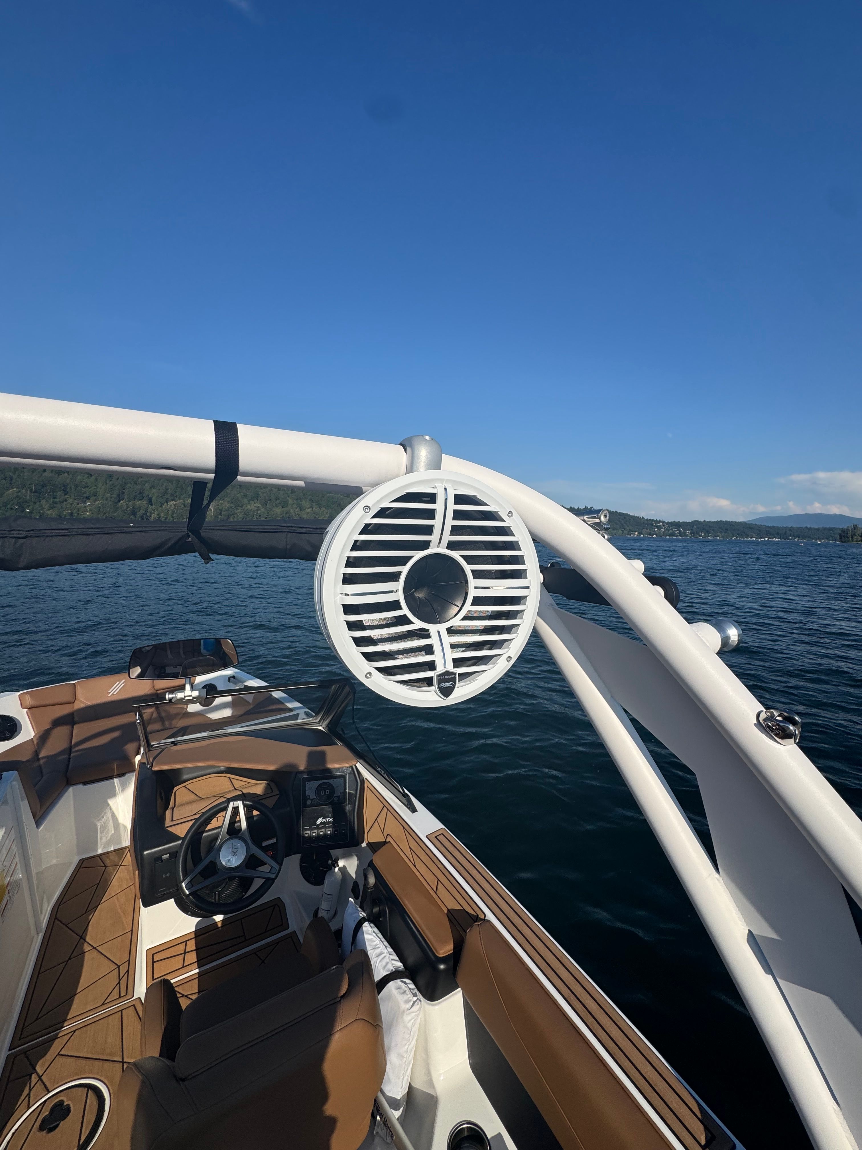An ATX Surf Boat 22 Type-S from 2022 on a lake with a blue sky.