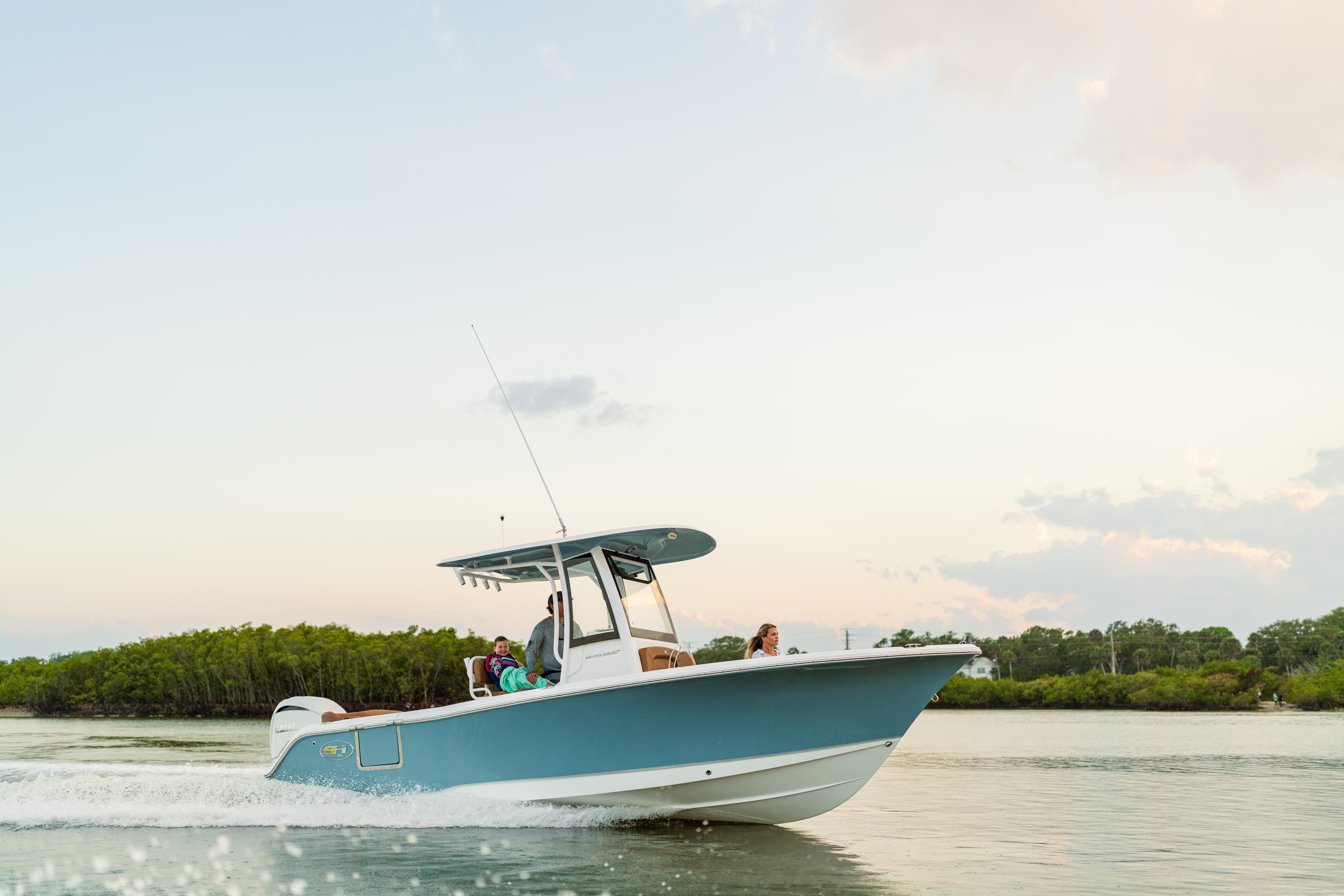 2026 Sea Hunt Ultra 235 SE boat cruising on calm water at sunset.