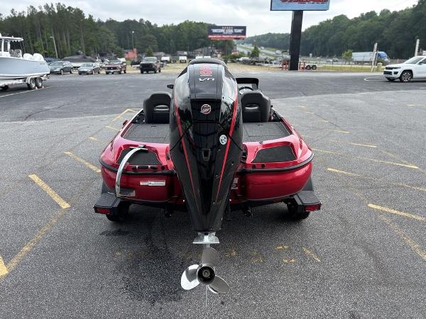 Red Nitro Z19 Pro 2025 boat with powerful outboard motor, parked in a lot.
