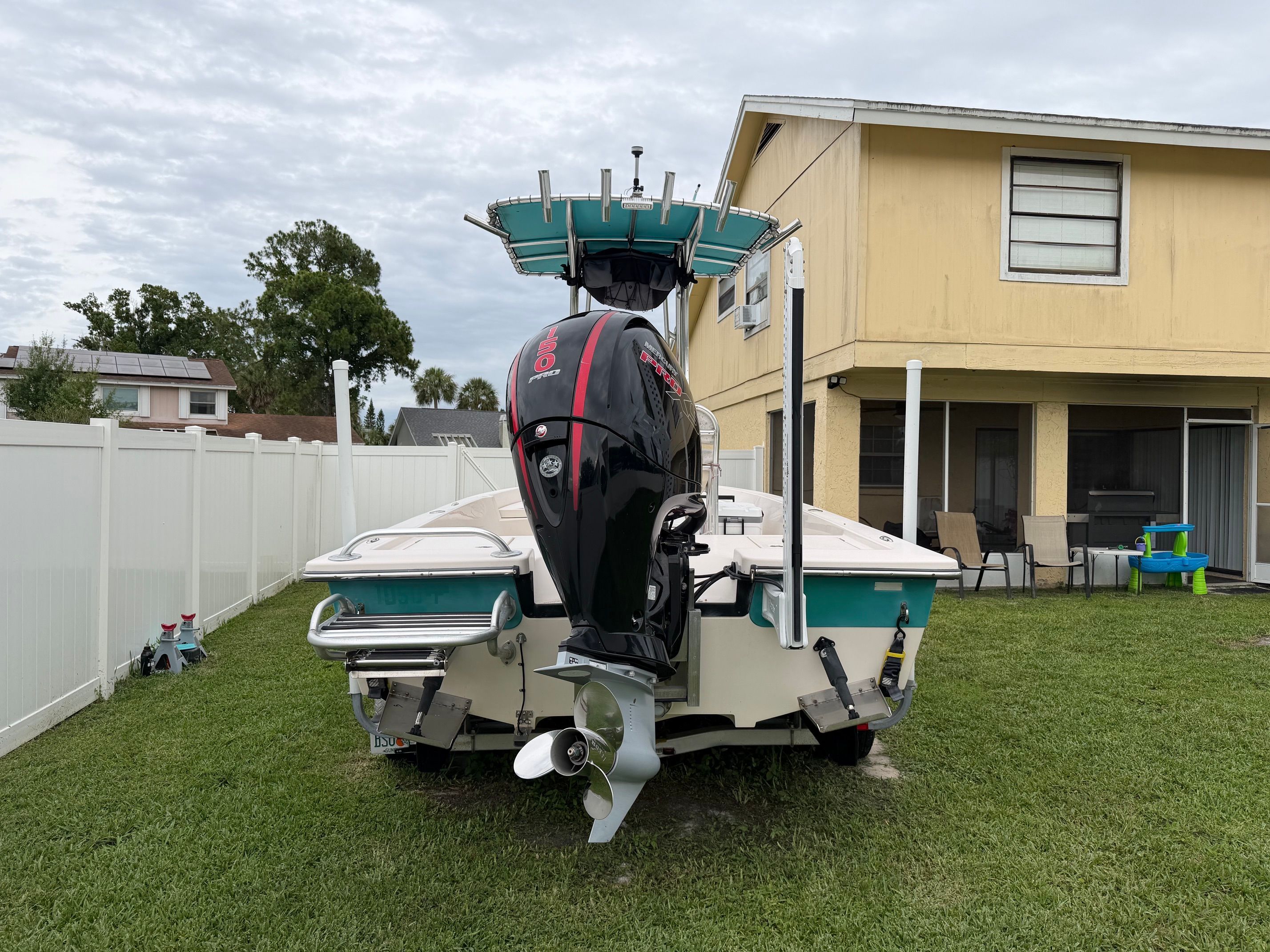 A 2006 Pathfinder 2200 Tournament Edition boat is on a lawn in front of a house.