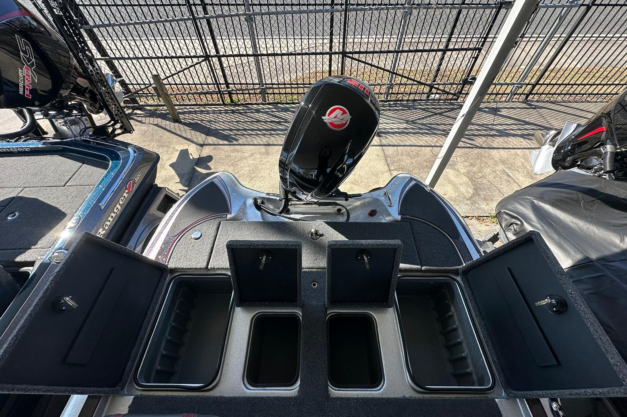 2026 Triton 179 TrX boat with open storage compartments and visible outboard motor.
