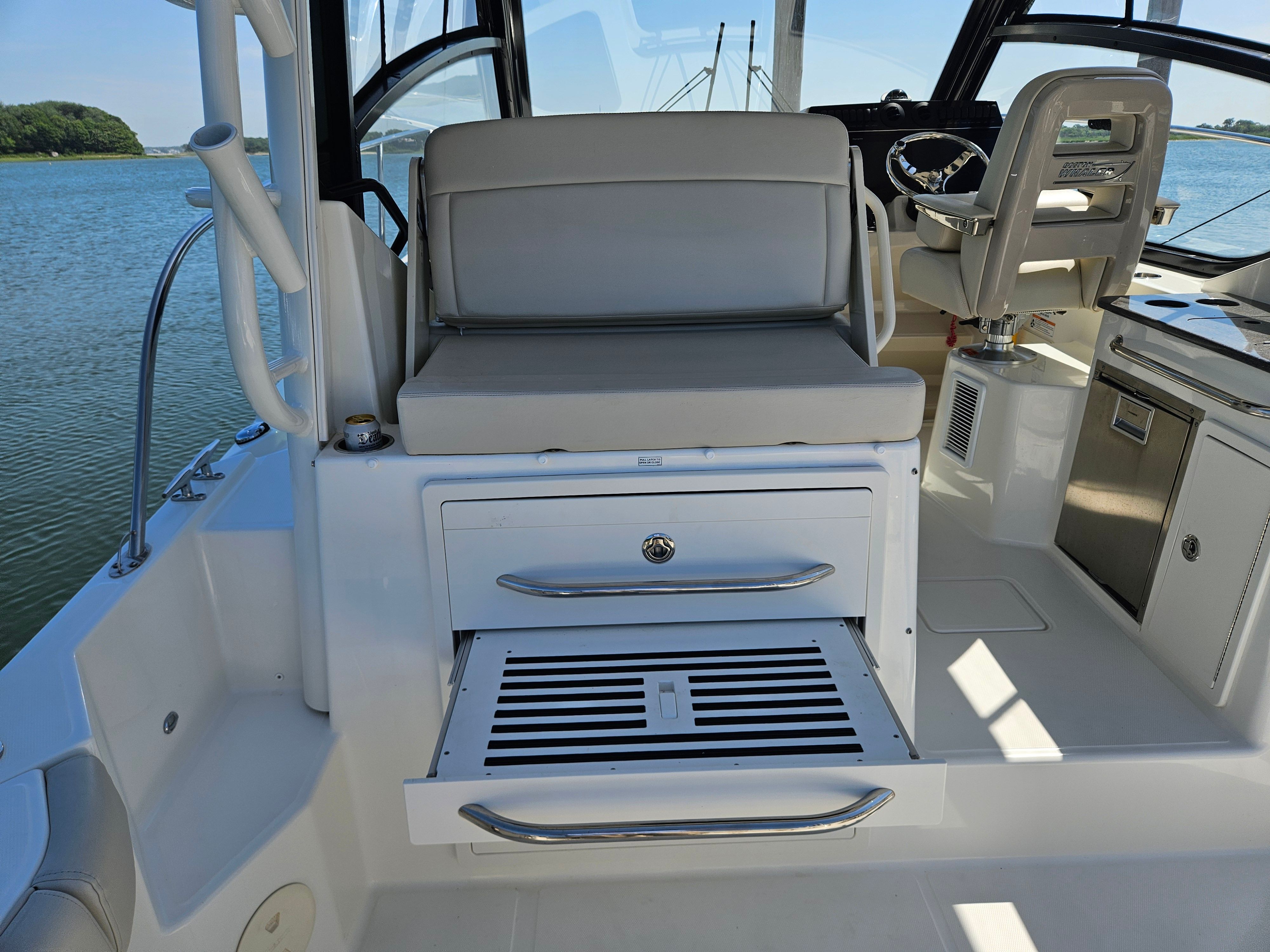 The image shows the cockpit of a Boston Whaler 325 Conquest with seating and drawers.