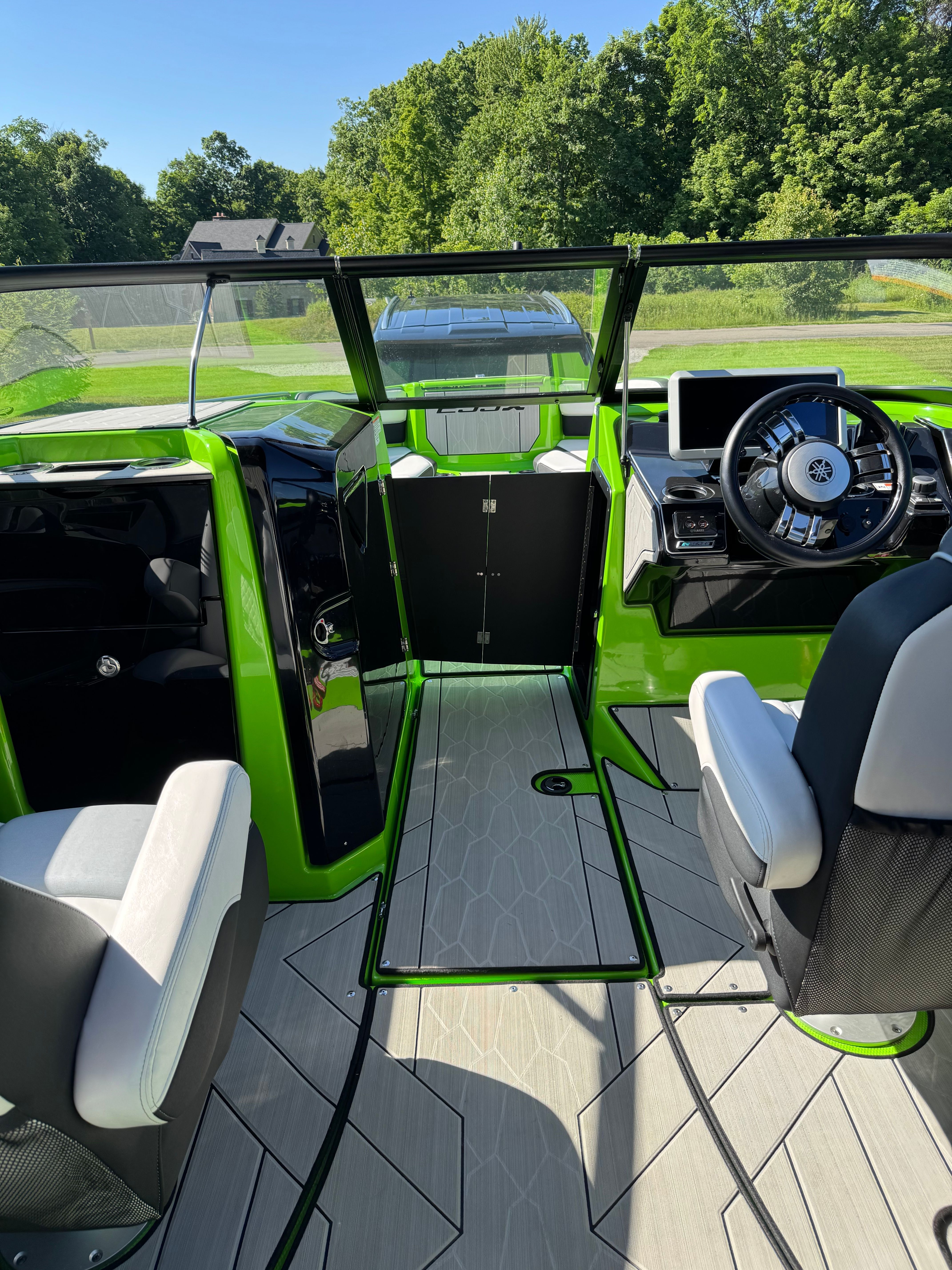 The image shows the cockpit of a 2022 Yamaha Boats 255XD with green accents.