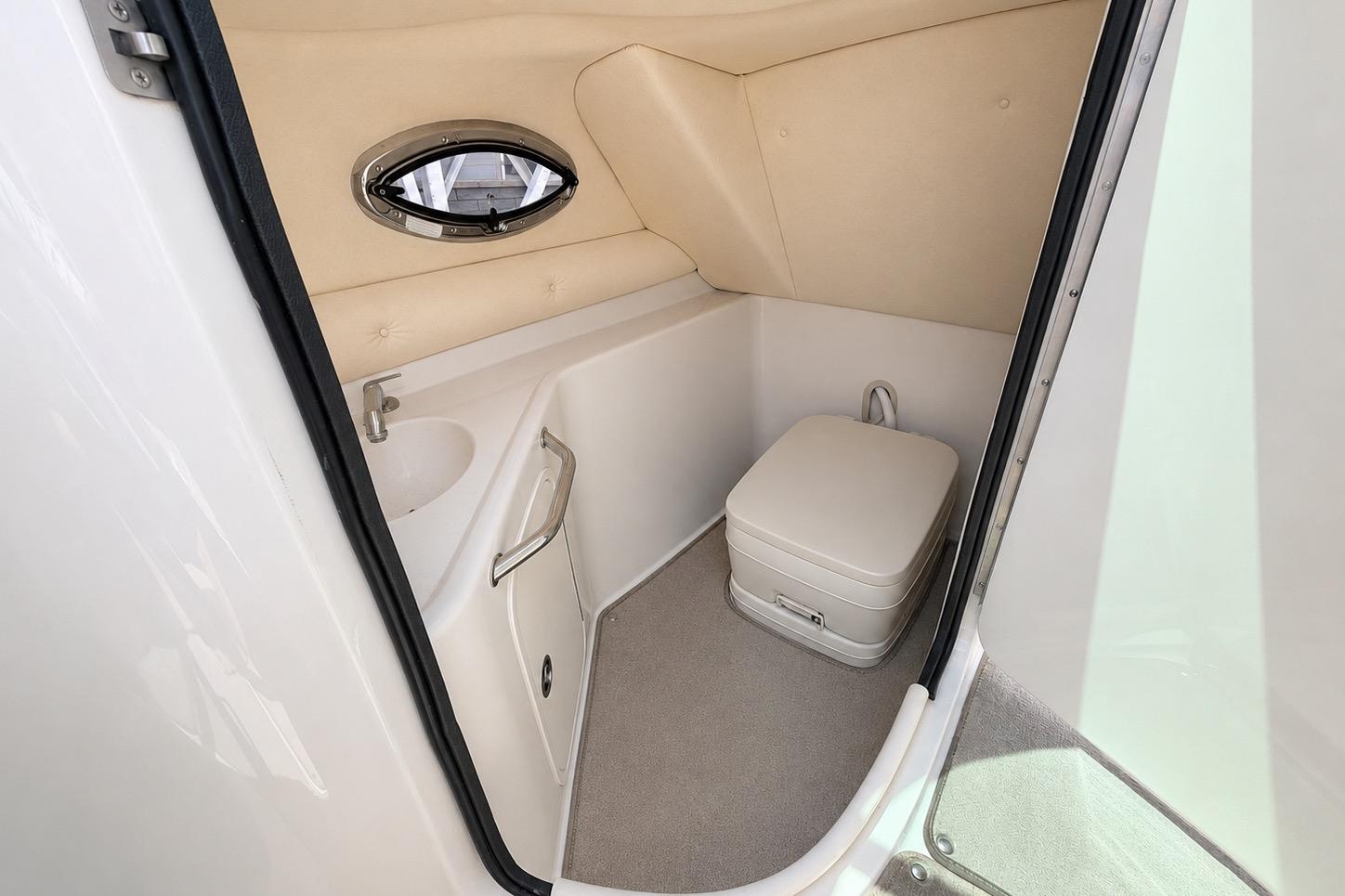 2004 Sea Ray 240 Sundeck boat bathroom with compact toilet and sink.
