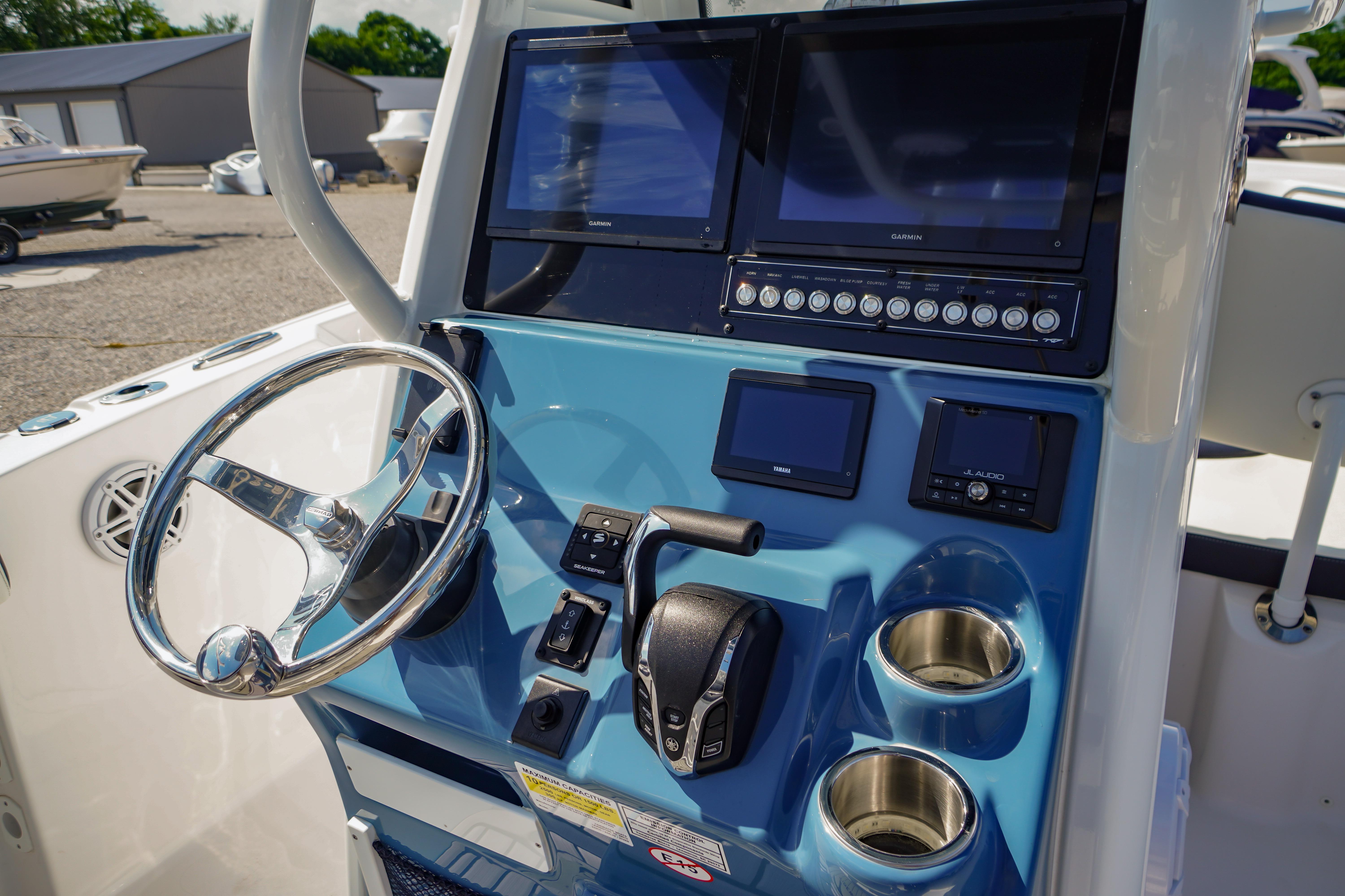 2025 Tidewater 232 SS boat dashboard with steering wheel, dual screens, and control panel.