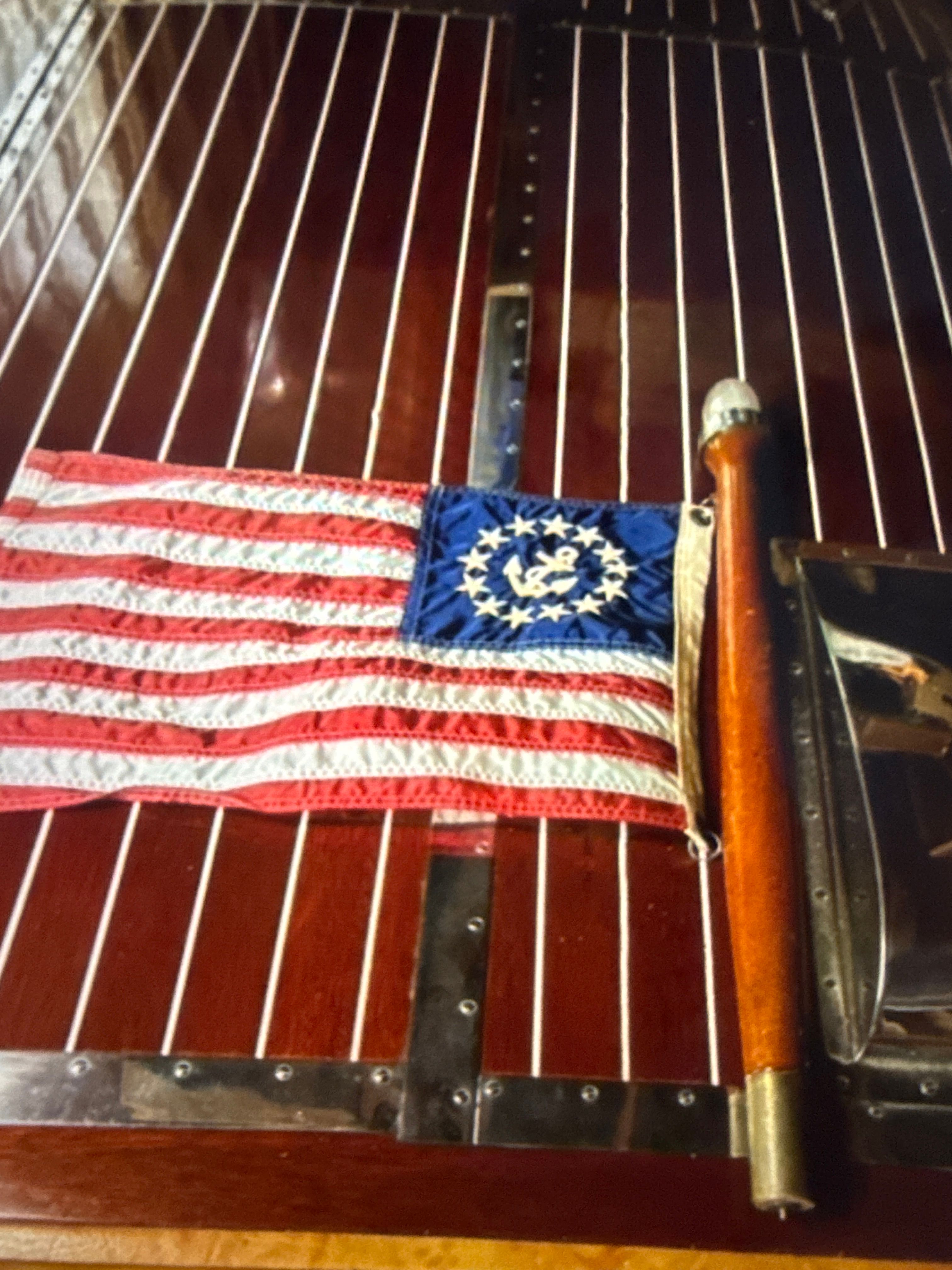 1940 Chris-Craft Barrelback with American flag on wooden deck.