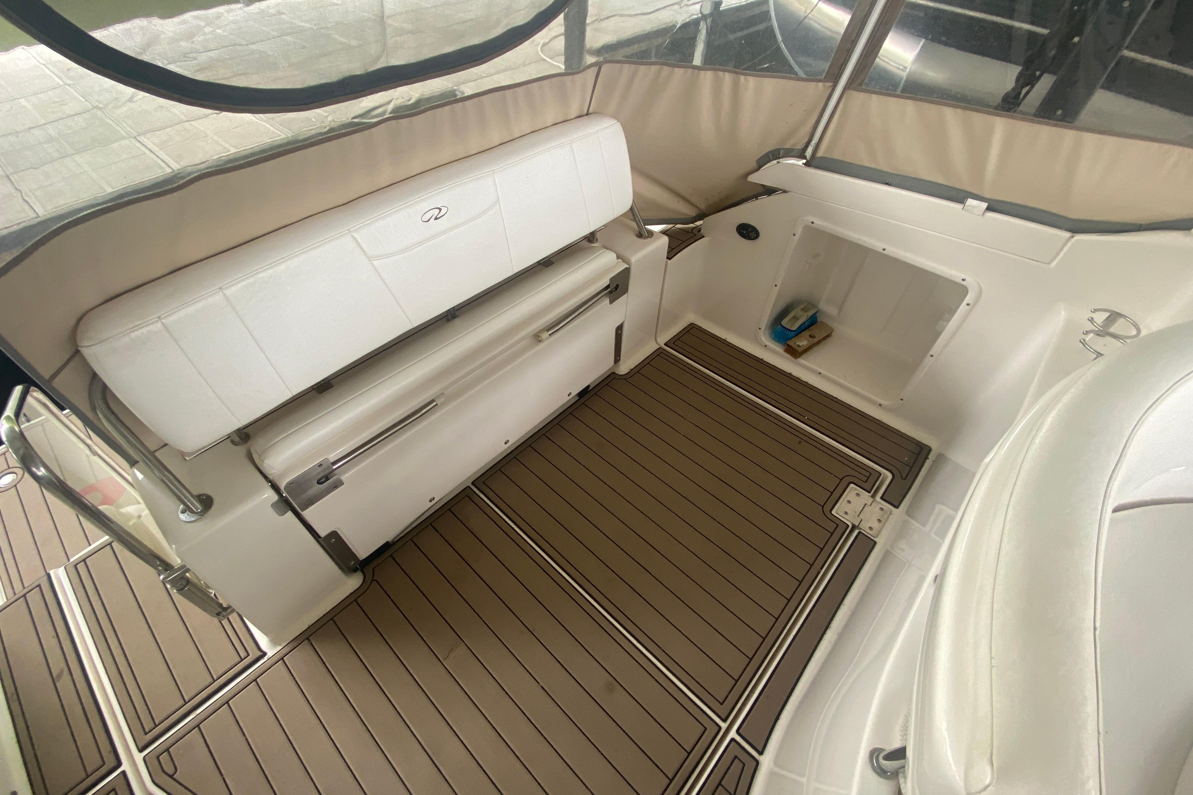2008 Regal 3360 Window Express boat interior with cushioned seating and wood-patterned flooring.