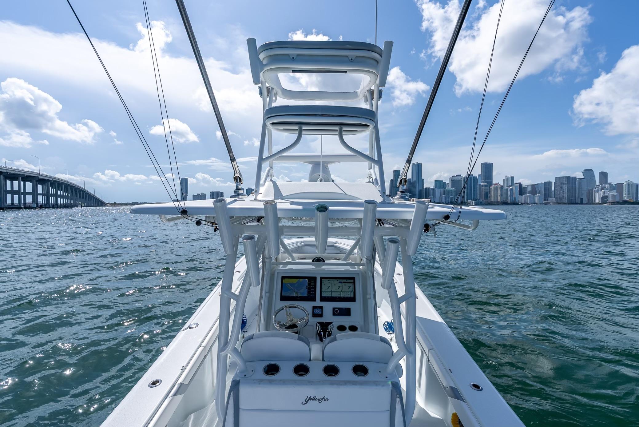2021 Yellowfin 34 boat navigating near city skyline and bridge on a sunny day.