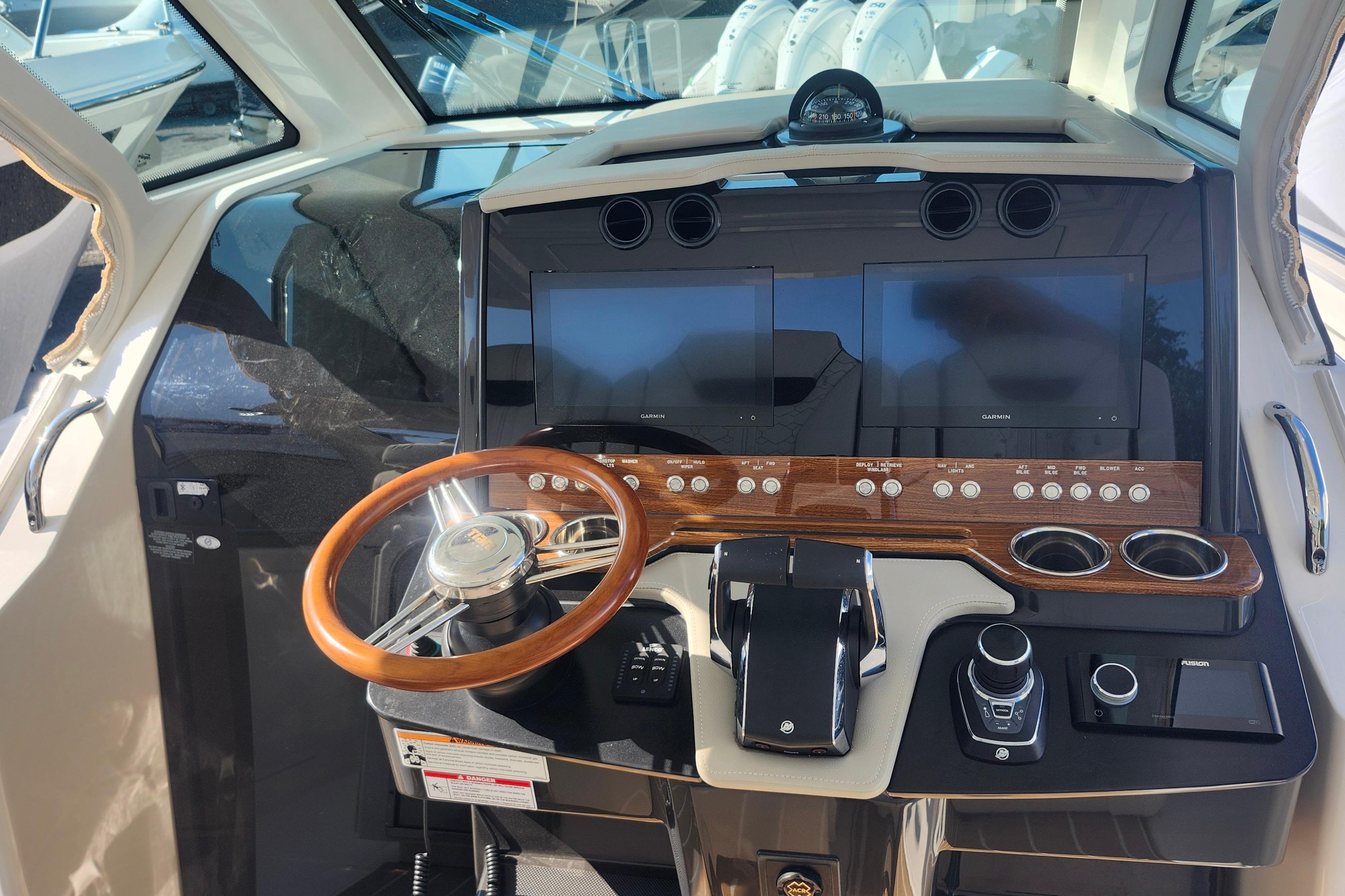 2024 Tiara Yachts 34 LS helm with dual screens, wooden accents, and modern controls.