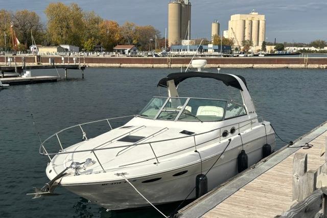 2000 Sea Ray Sundancer 310 docked at a marina with industrial buildings in the background.