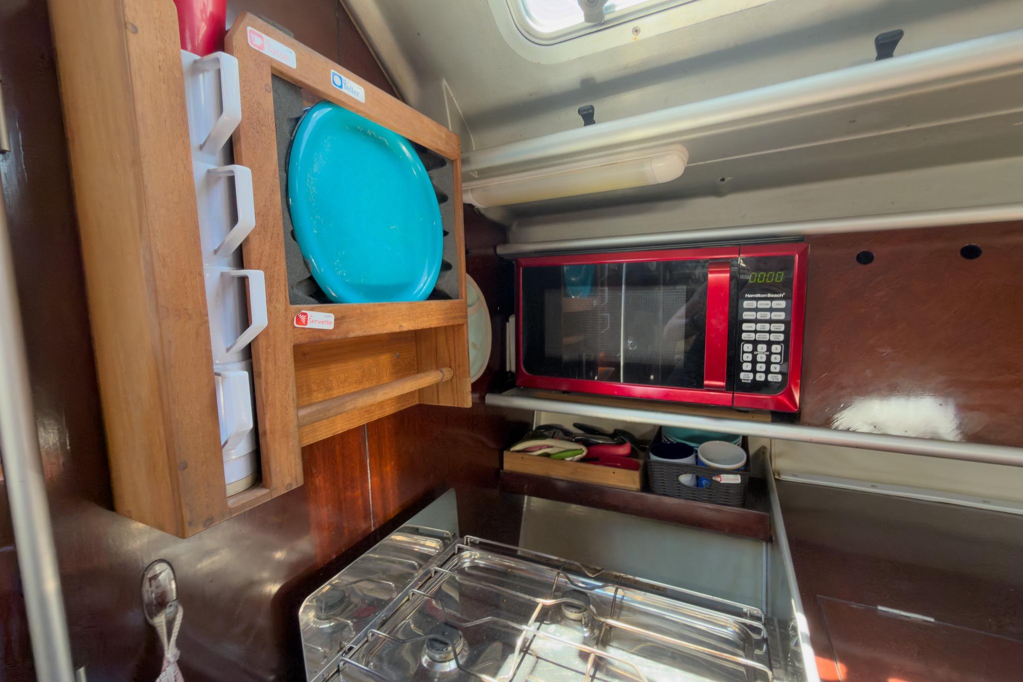 Galley of 1993 Beneteau First 38 s5 with microwave, dish rack, and stove.