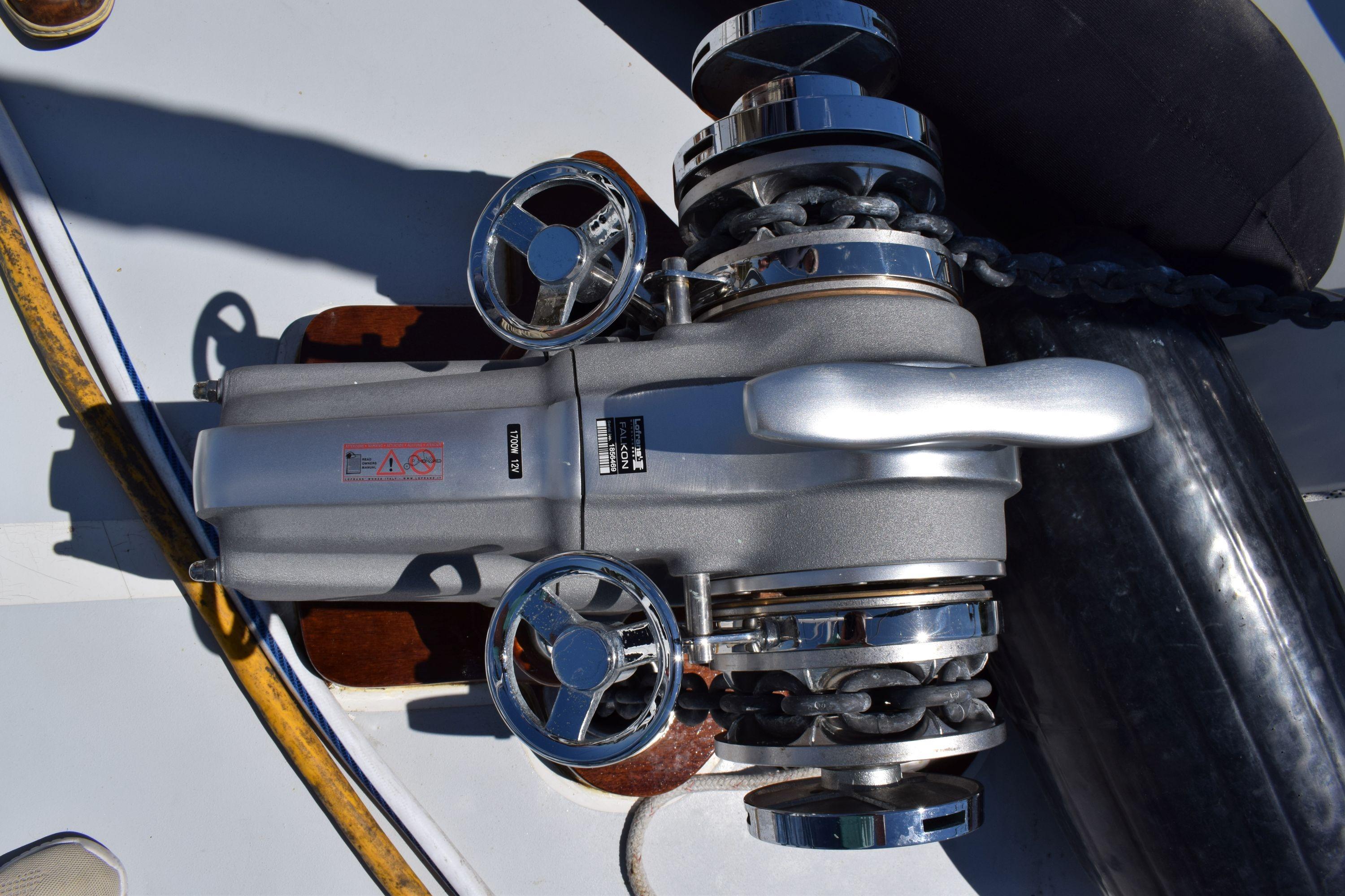 Anchor windlass on 1980 Cheoy Lee 52 Motorsailer deck, featuring chrome details and chain.