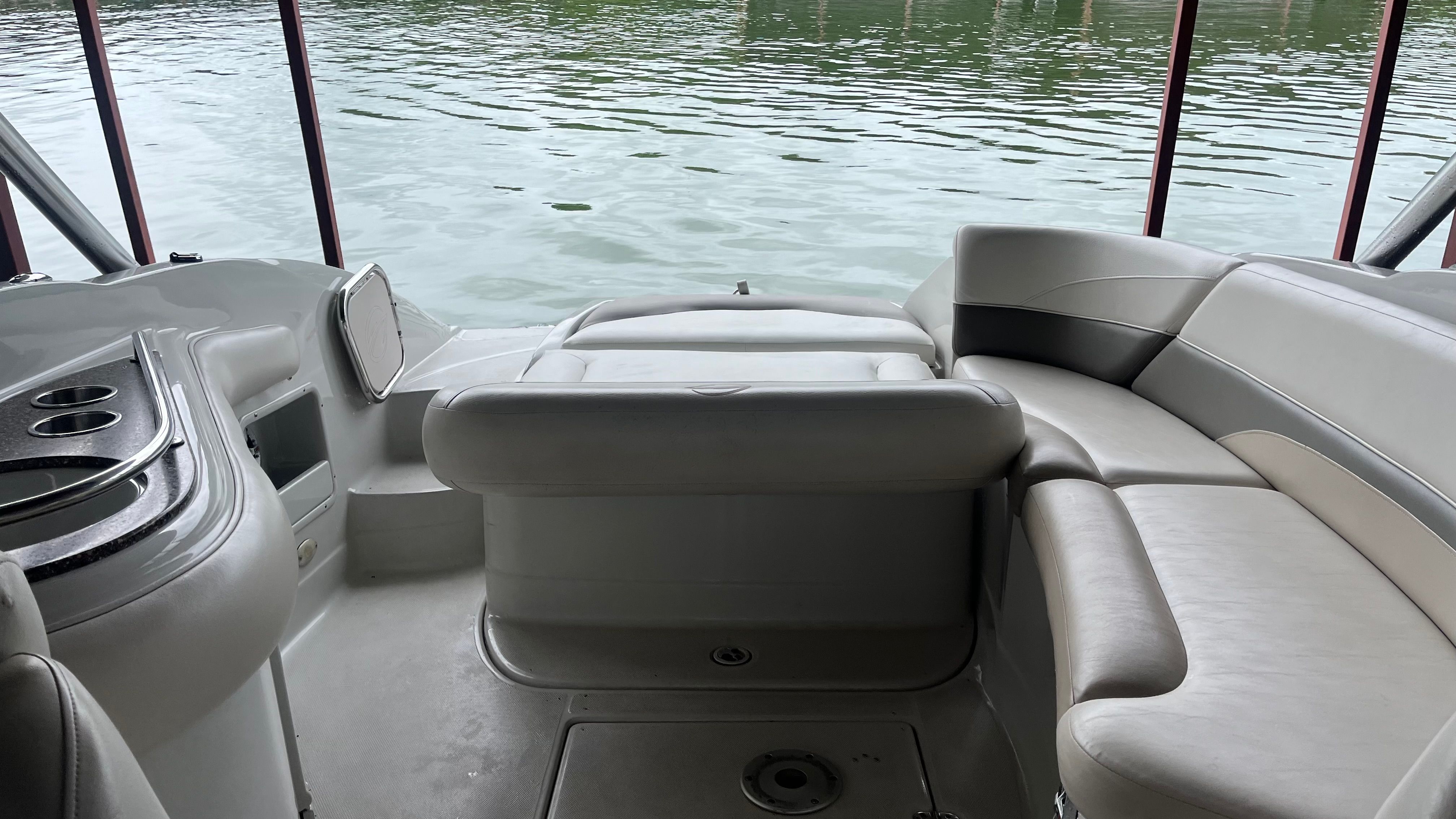 Interior of a 2008 Crownline 252EX with gray seating and a view of the water.