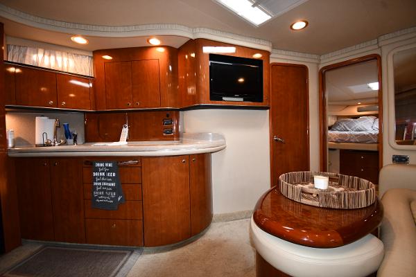 2003 Sea Ray 460 Sundancer interior with kitchen, TV, and seating area.