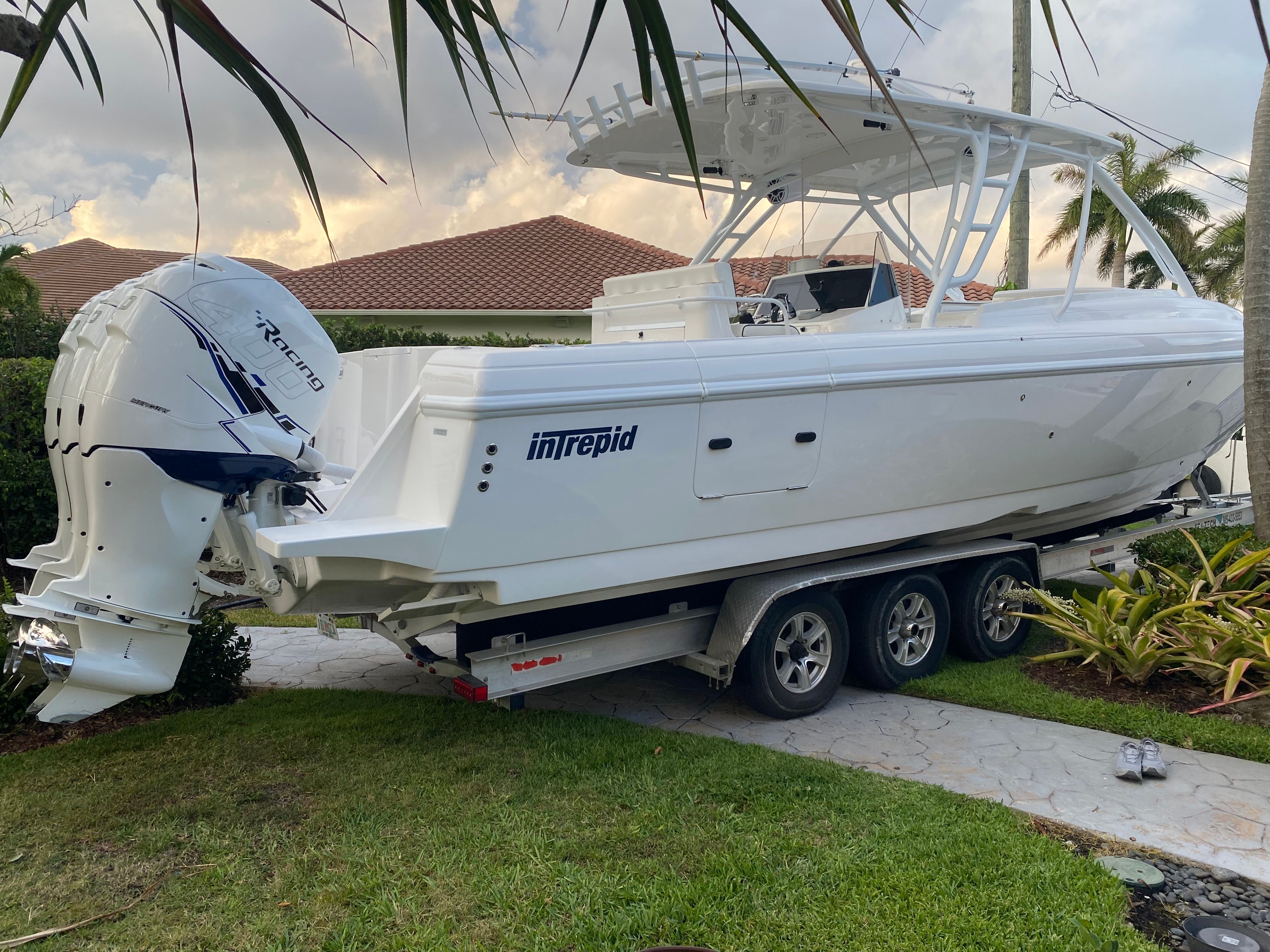 A 2011 Intrepid 37 boat on a trailer in a garden setting.