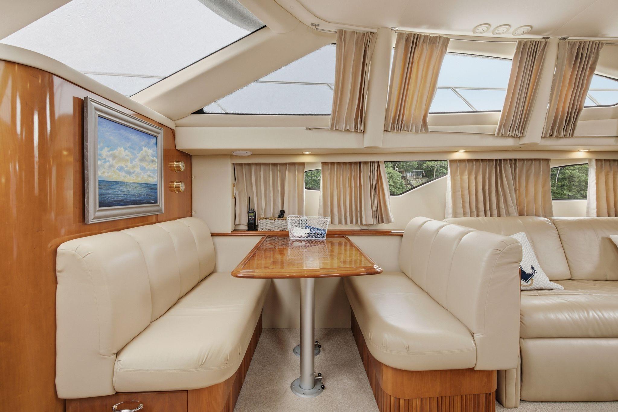 Luxurious interior of 2005 Carver 39 Motor Yacht with elegant seating and natural light.