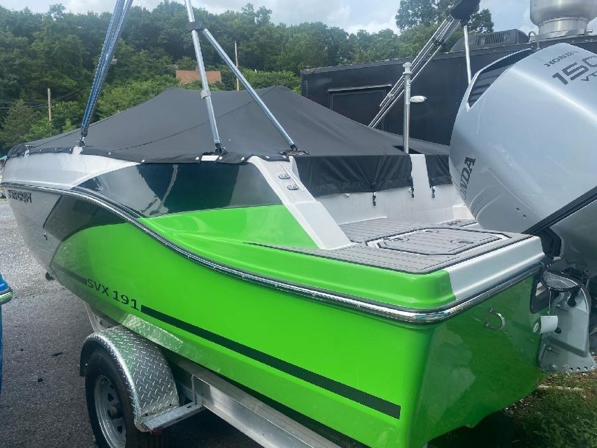 A bright green 2023 Starcraft SVX 191 OB boat on a trailer.