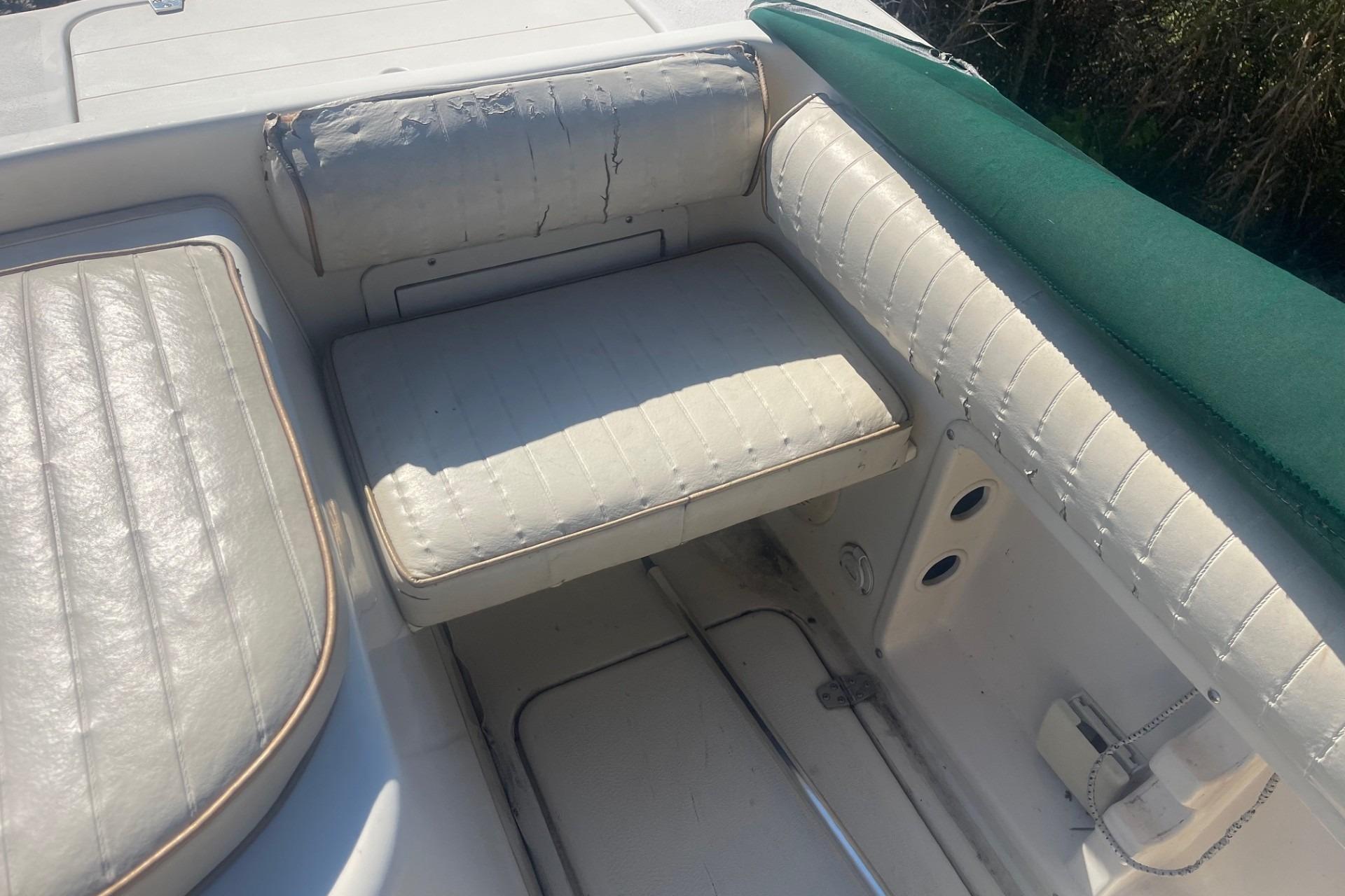 Worn seating area on a 2000 Seamaster 2388 WA boat with white upholstery.