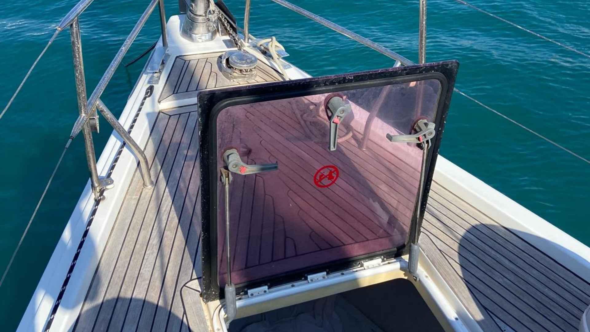 Hanse 495 yacht deck with open hatch, 2012 model, on clear blue water.