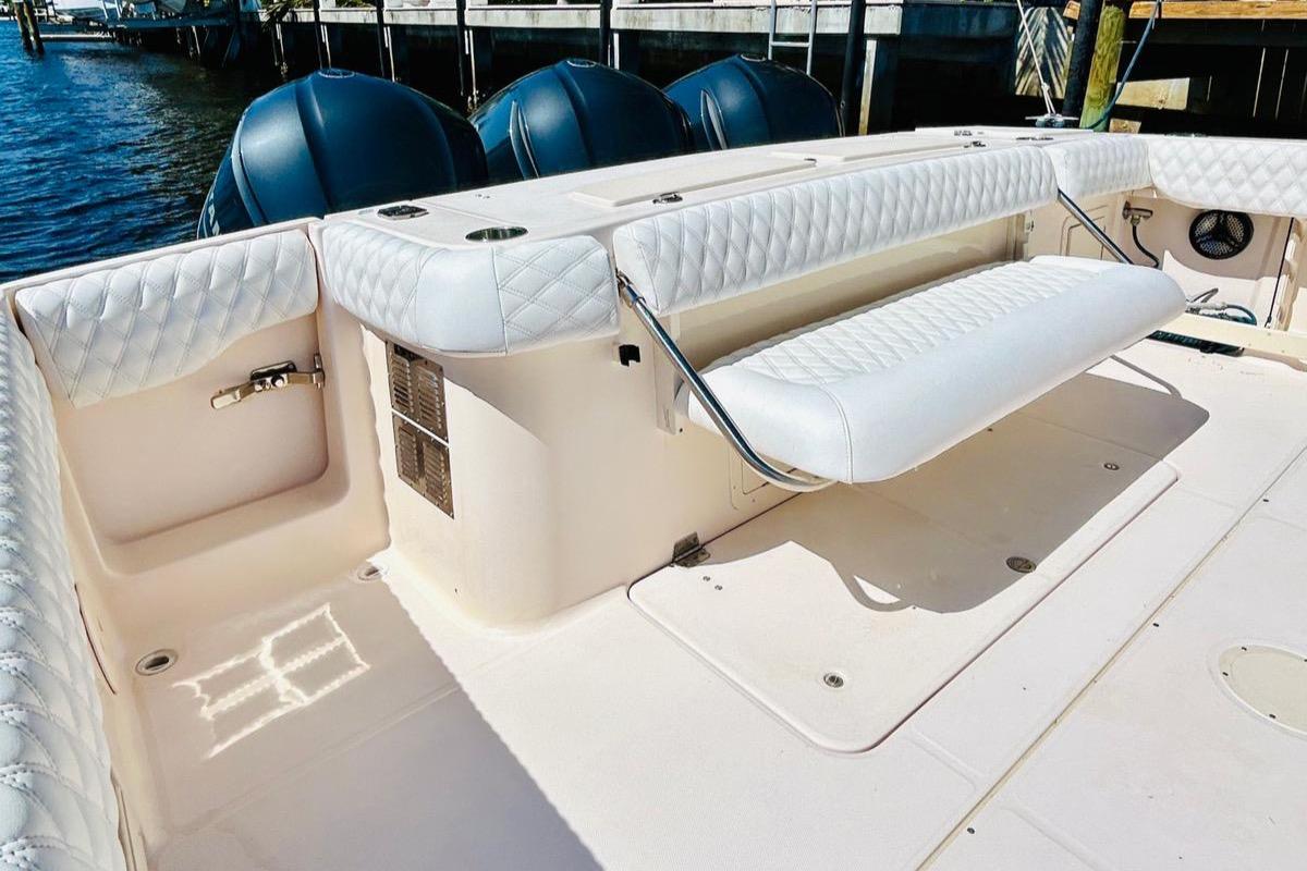 2012 Grady-White Canyon 366 boat with white cushioned seating and triple outboard motors.