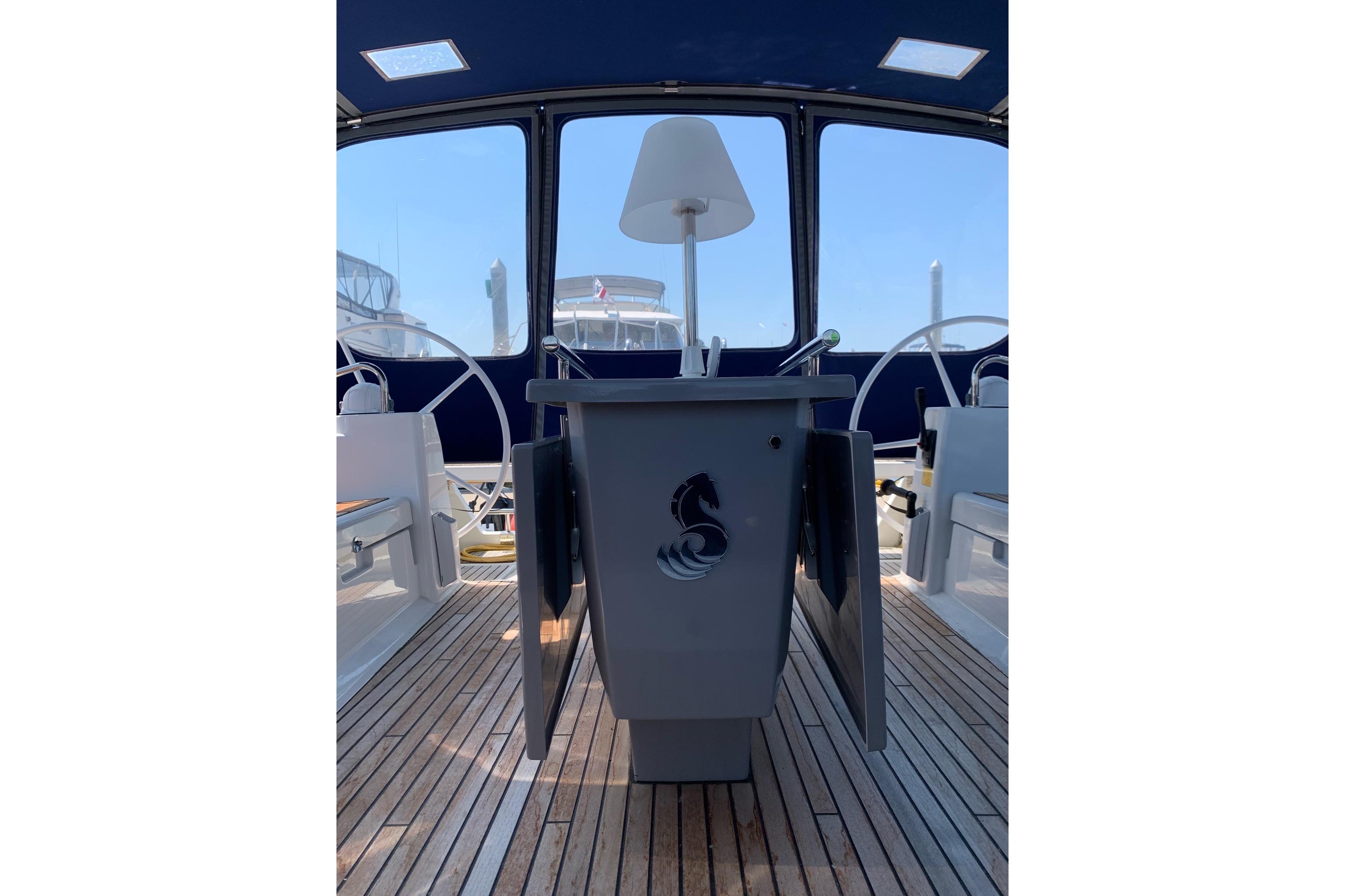 2018 Beneteau Oceanis 45 yacht cockpit with wooden deck and steering wheels.
