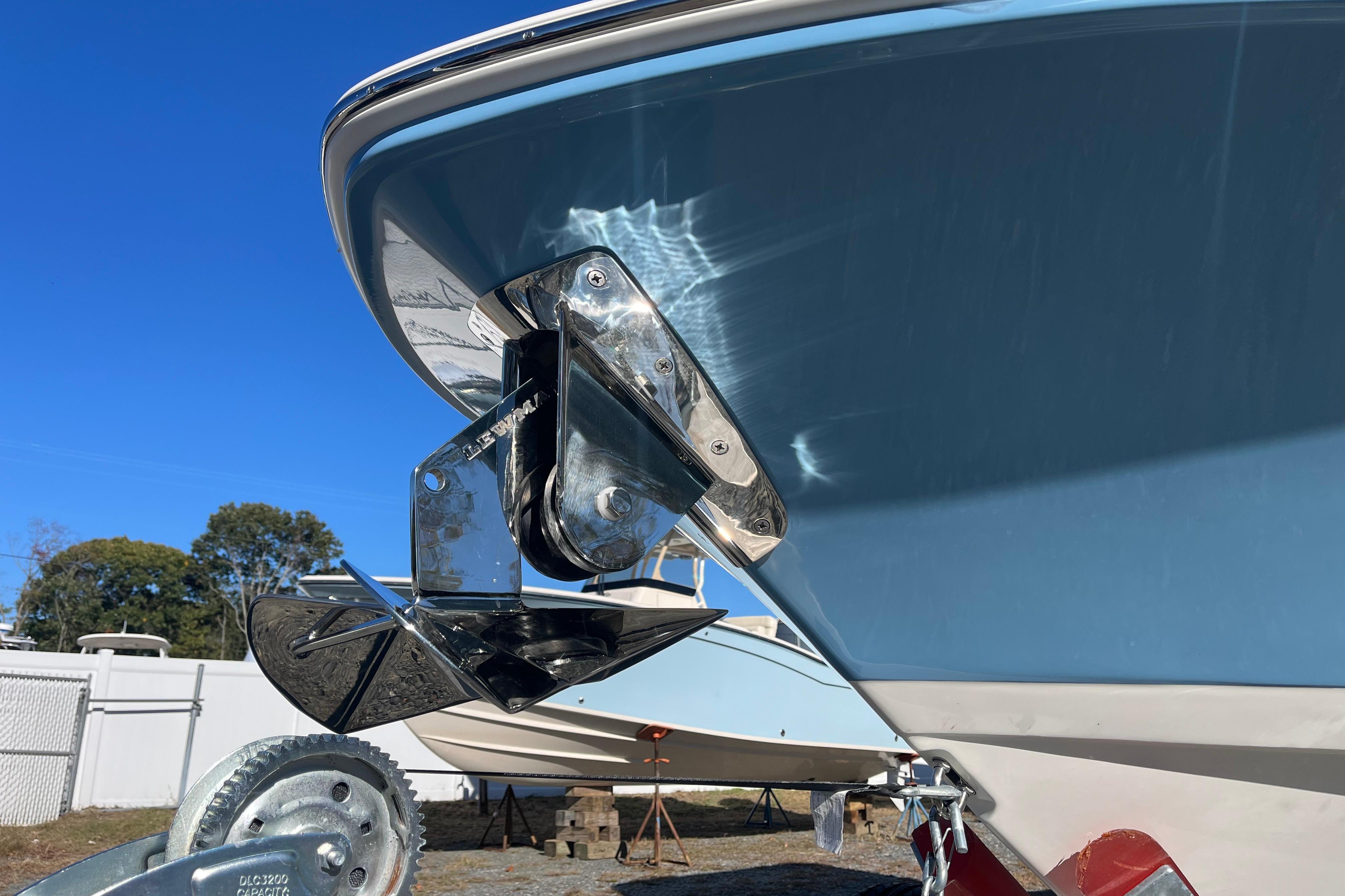 Boston Whaler 280 Dauntless 2026 boat with anchor detail against clear blue sky.