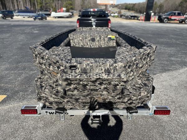 2025 Havoc 1656 VJST boat with camouflage design on a trailer in a parking lot.