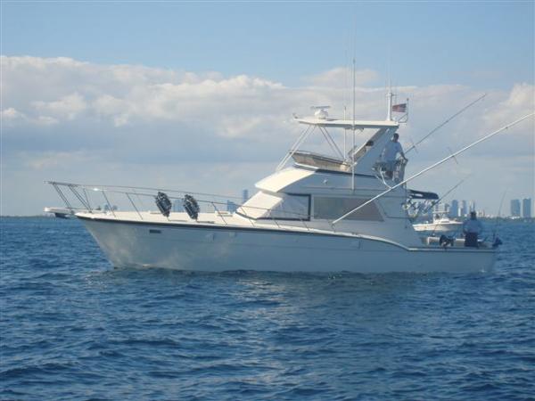 1985 Hatteras 45 Convertible yacht cruising on open water under a clear sky.