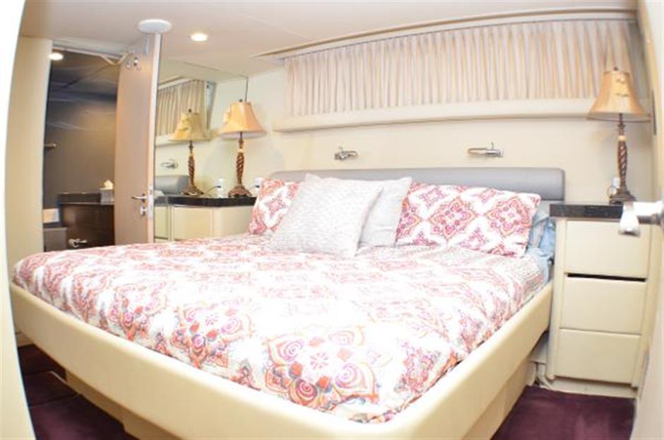 Luxurious bedroom in 1990 Broward Raised Pilothouse MY yacht with elegant bedding and decor.