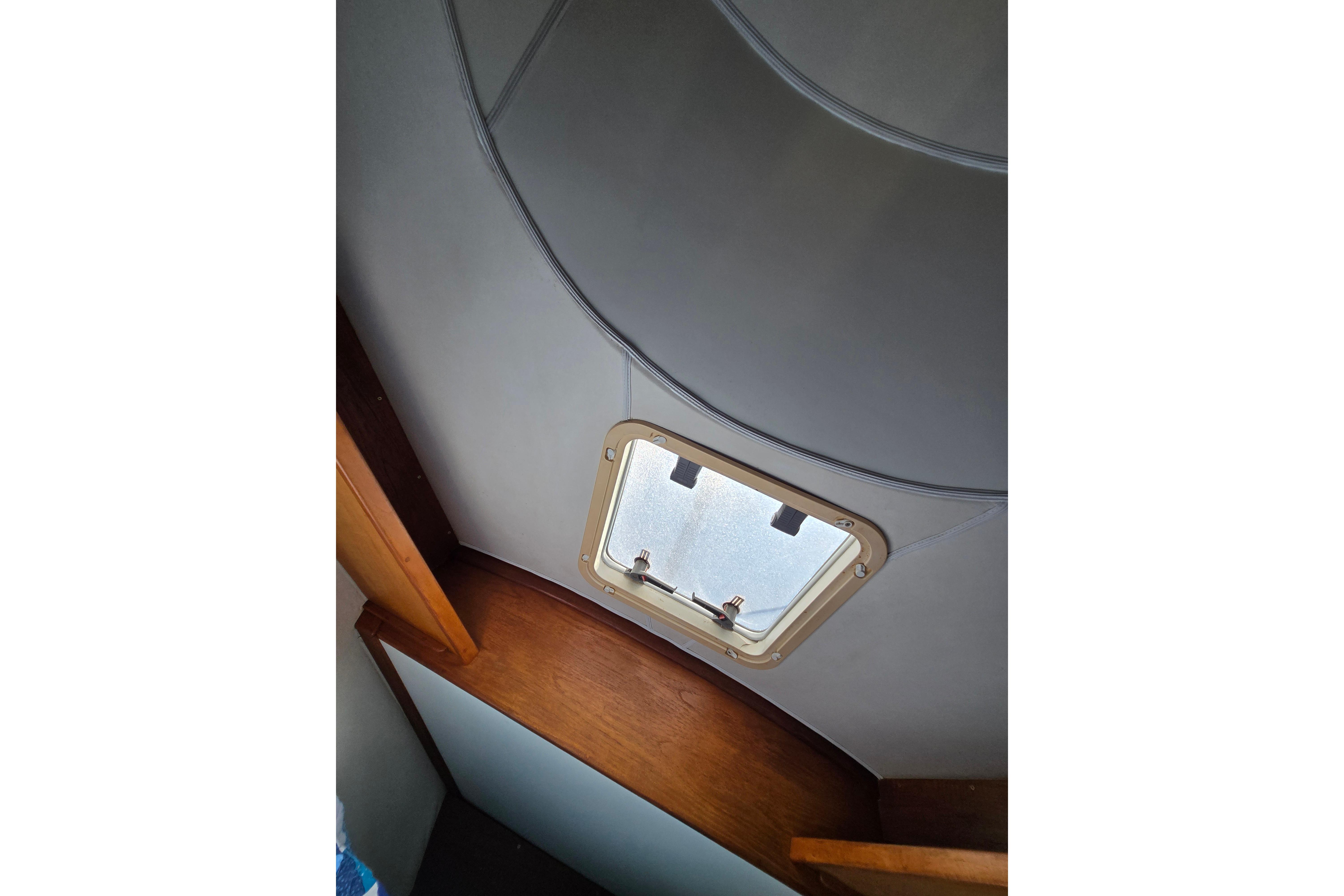Interior view of a 1993 Caliber 35 sailboat, featuring a ceiling hatch.