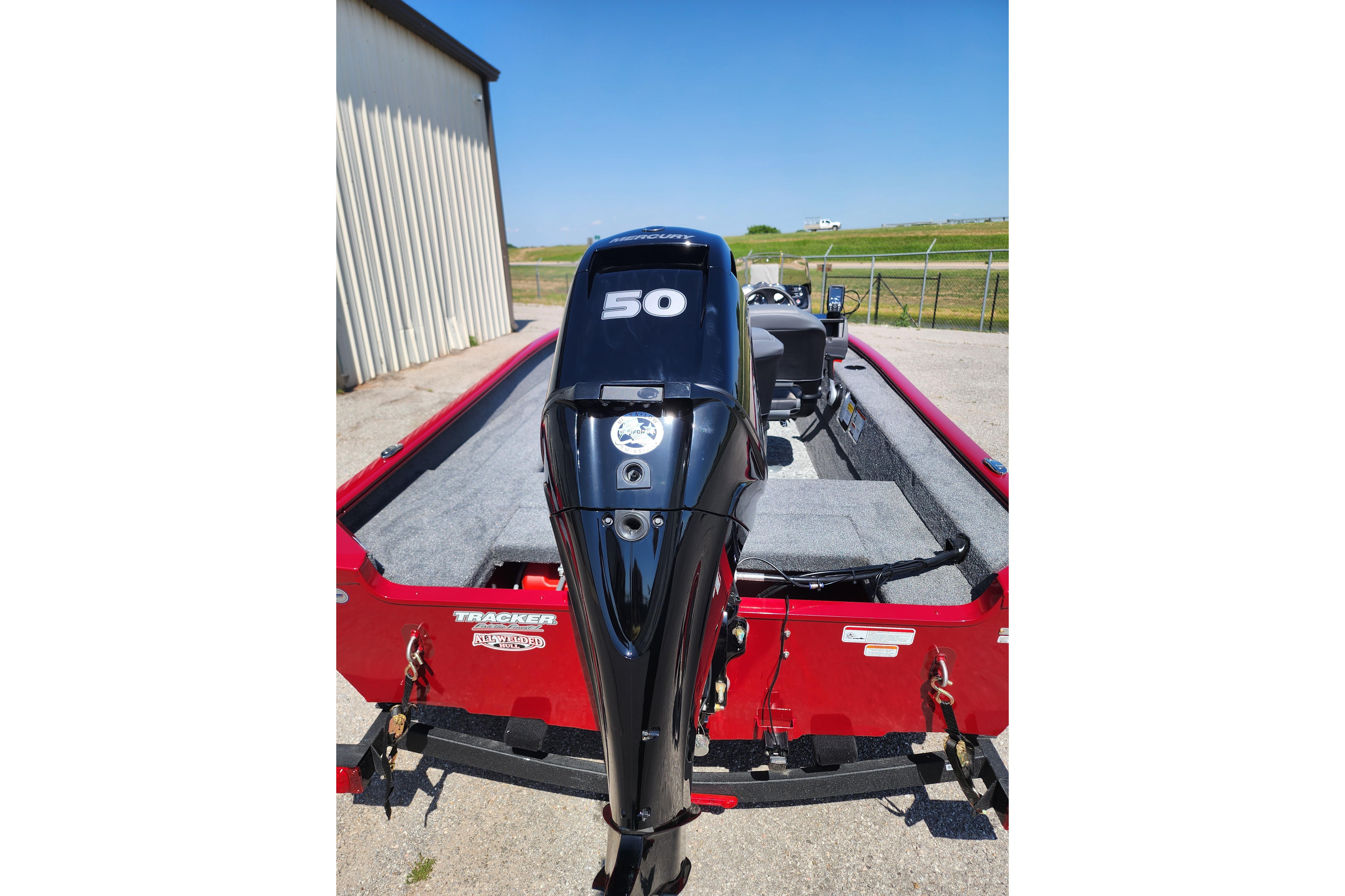 2026 Tracker Super Guide V-16 SC boat with a 50 HP outboard motor, parked outdoors.
