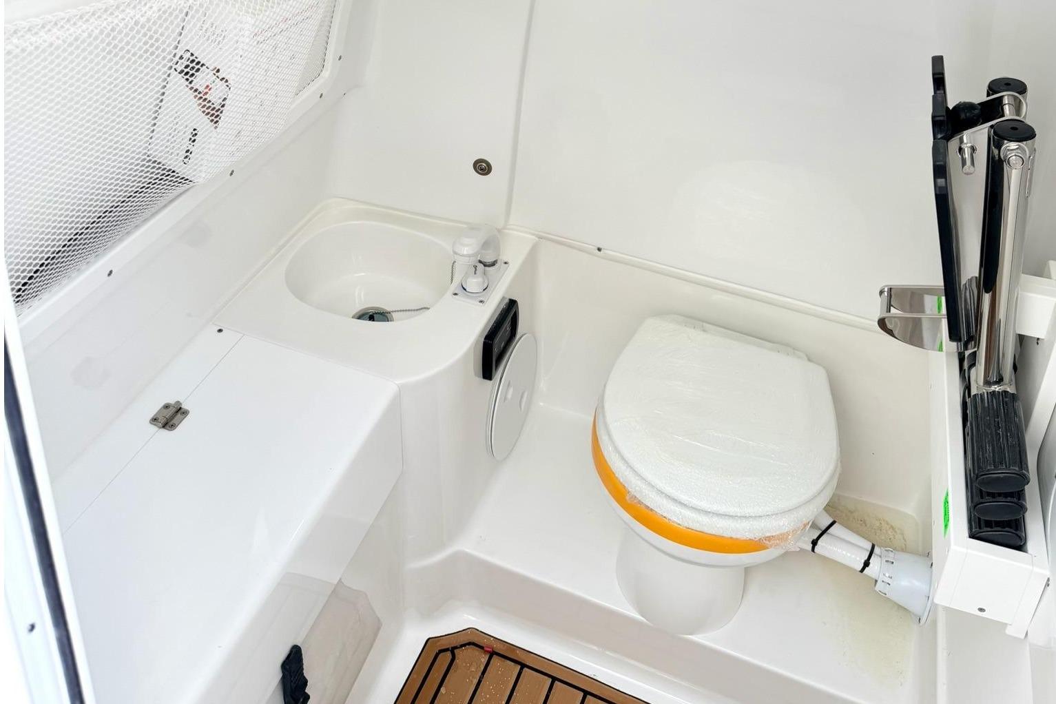 Interior of Sea Hunt Ultra 305 Coffin Box 2026 with toilet and sink.
