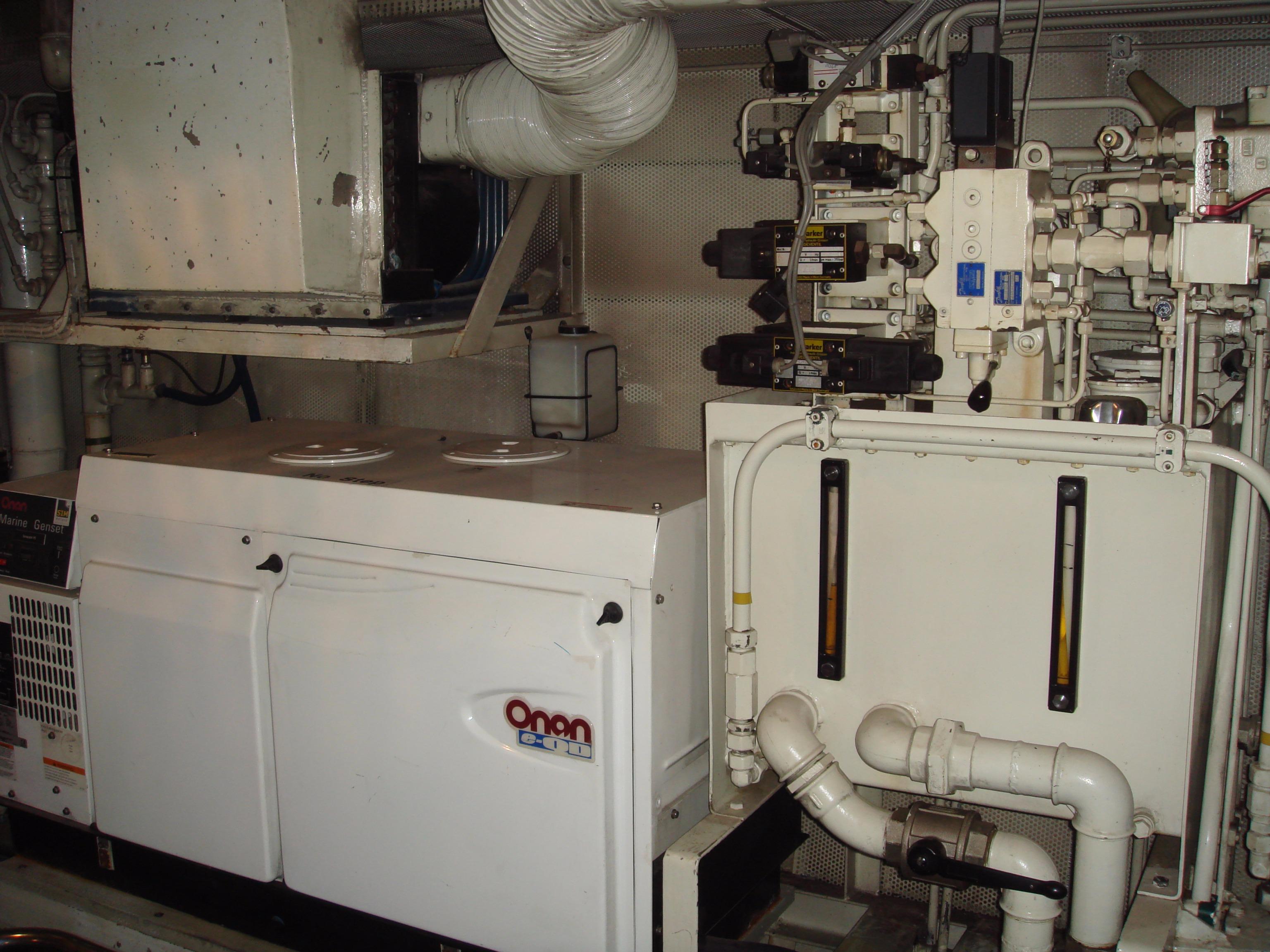 Engine room of a 1987 Moonen 72 yacht featuring Onan generator and complex piping system.